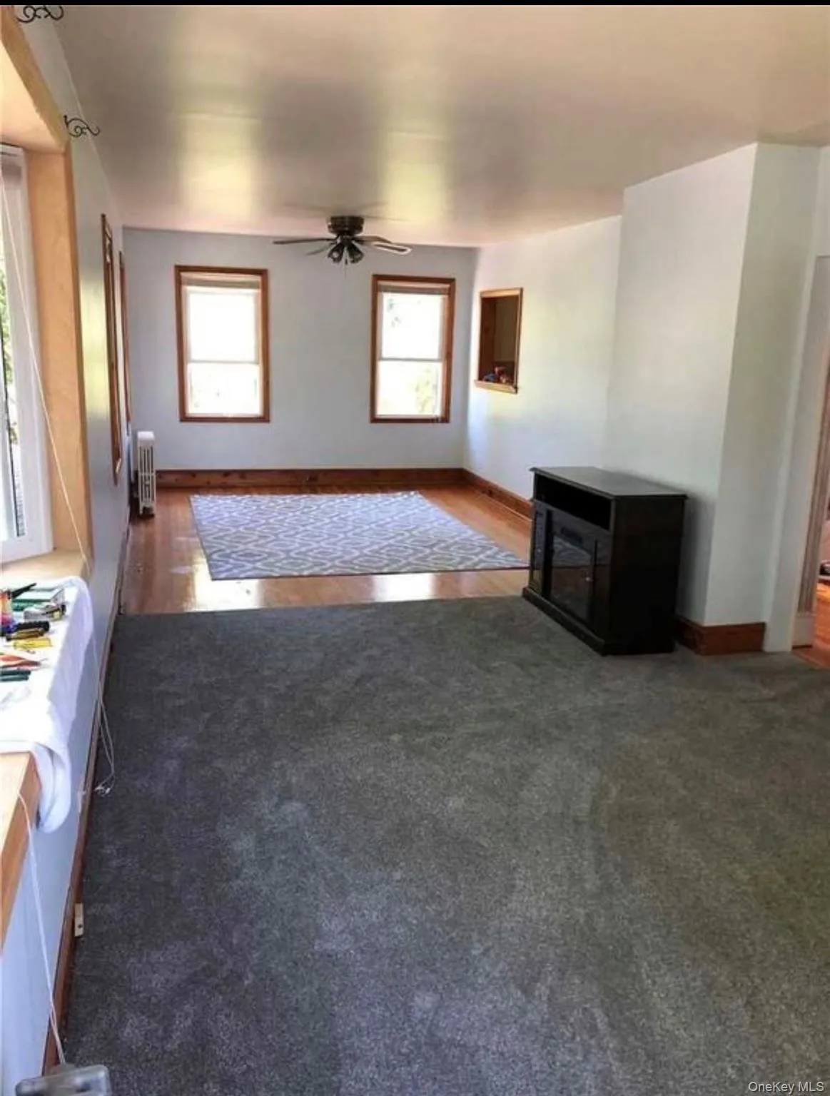 Spacious interior featuring a combination of gray carpeting and wood-finish flooring Spacious interior featuring a combination of gray carpeting and wood-finish flooring