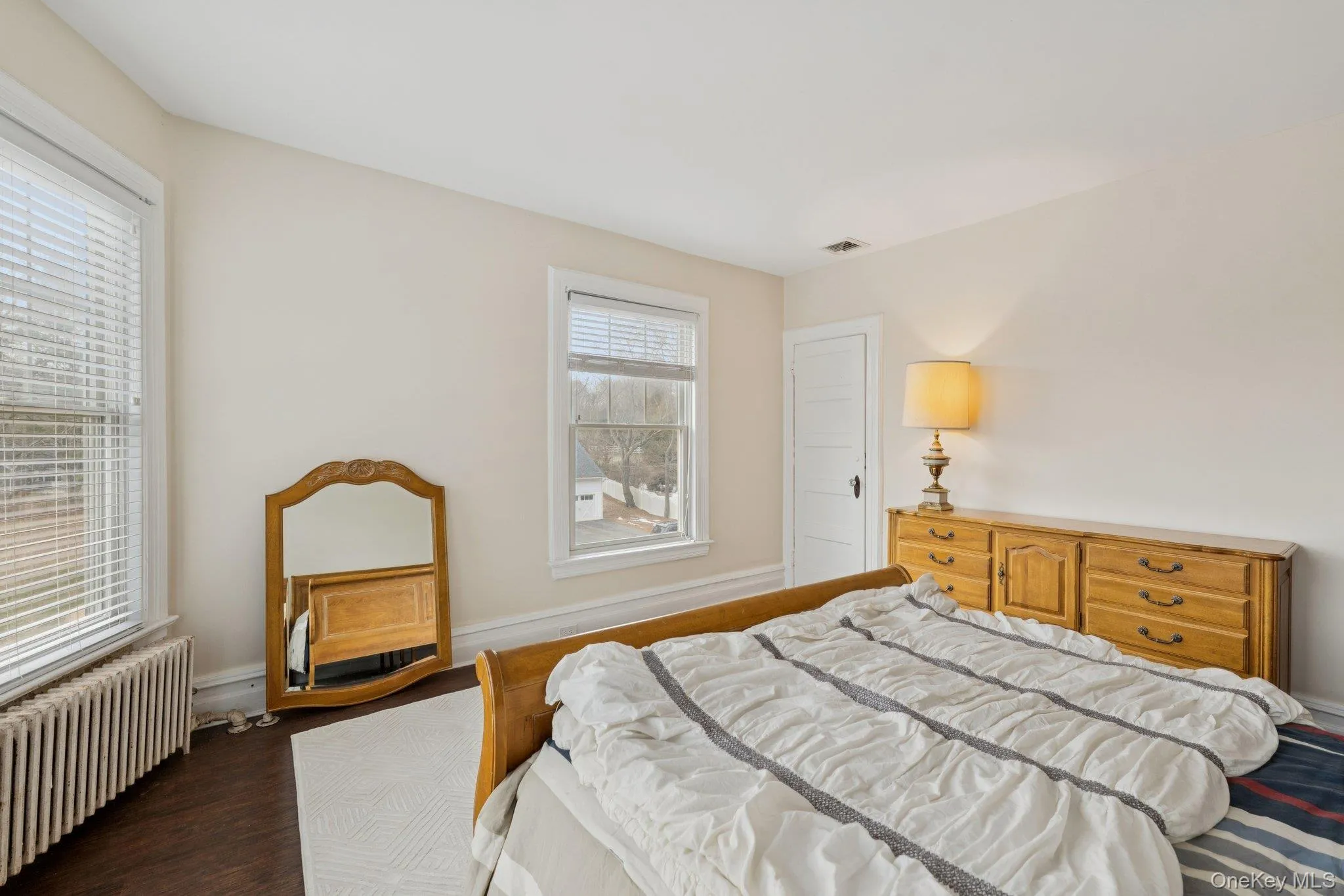 Bedroom featuring radiator heating unit and wood finished floors Bedroom featuring radiator heating unit and wood finished floors