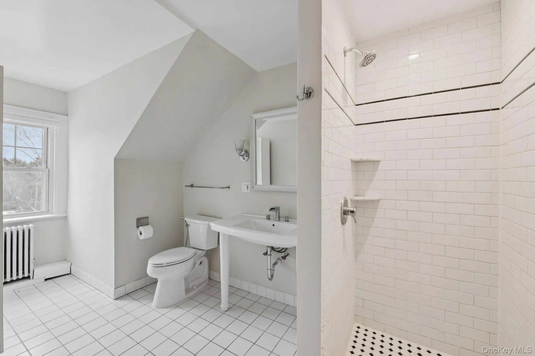 Bathroom featuring radiator, a stall shower, lofted ceiling, and light tile patterned floors Bathroom featuring radiator, a stall shower, lofted ceiling, and light tile patterned floors