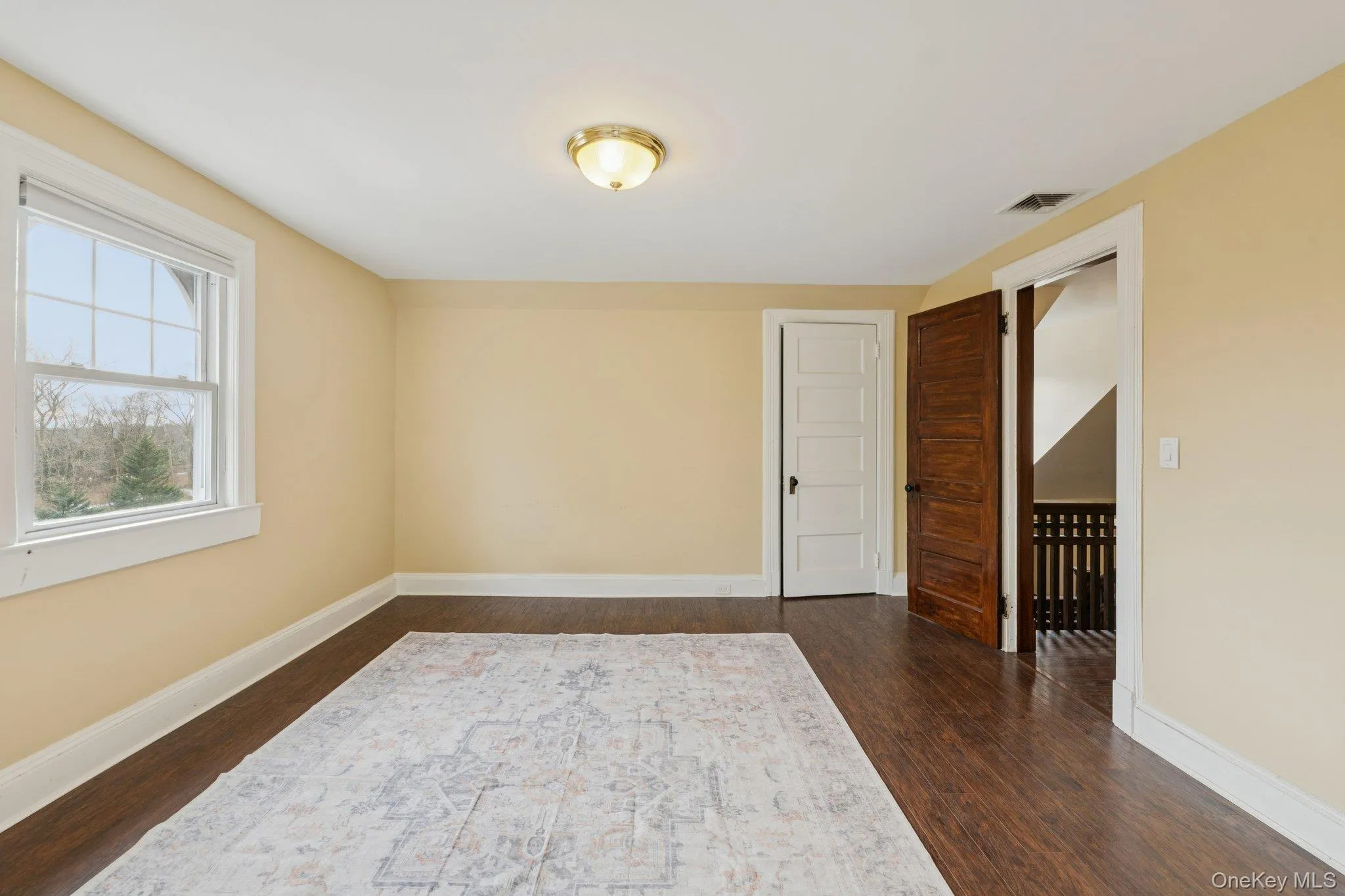 Empty room featuring baseboards and dark wood-style flooring Empty room featuring baseboards and dark wood-style flooring