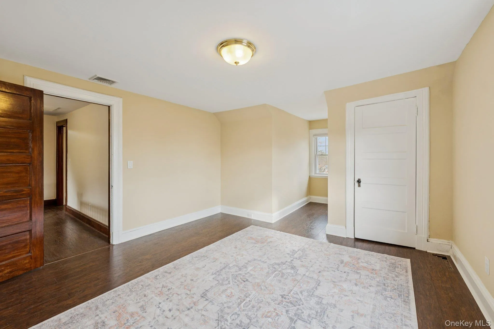 Empty room featuring baseboards and dark wood-style flooring Empty room featuring baseboards and dark wood-style flooring