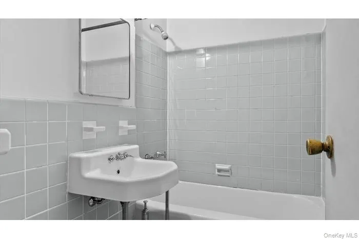 Bathroom with shower / tub combination and tile walls Bathroom with shower / tub combination and tile walls