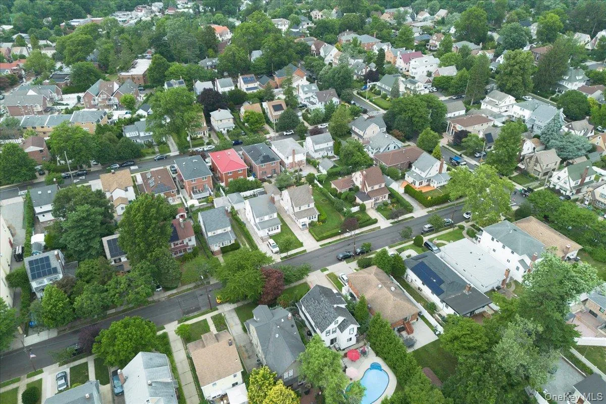 Aerial perspective of a residential street with mature trees and a variety of architectural styles Aerial perspective of a residential street with mature trees and a variety of architectural styles