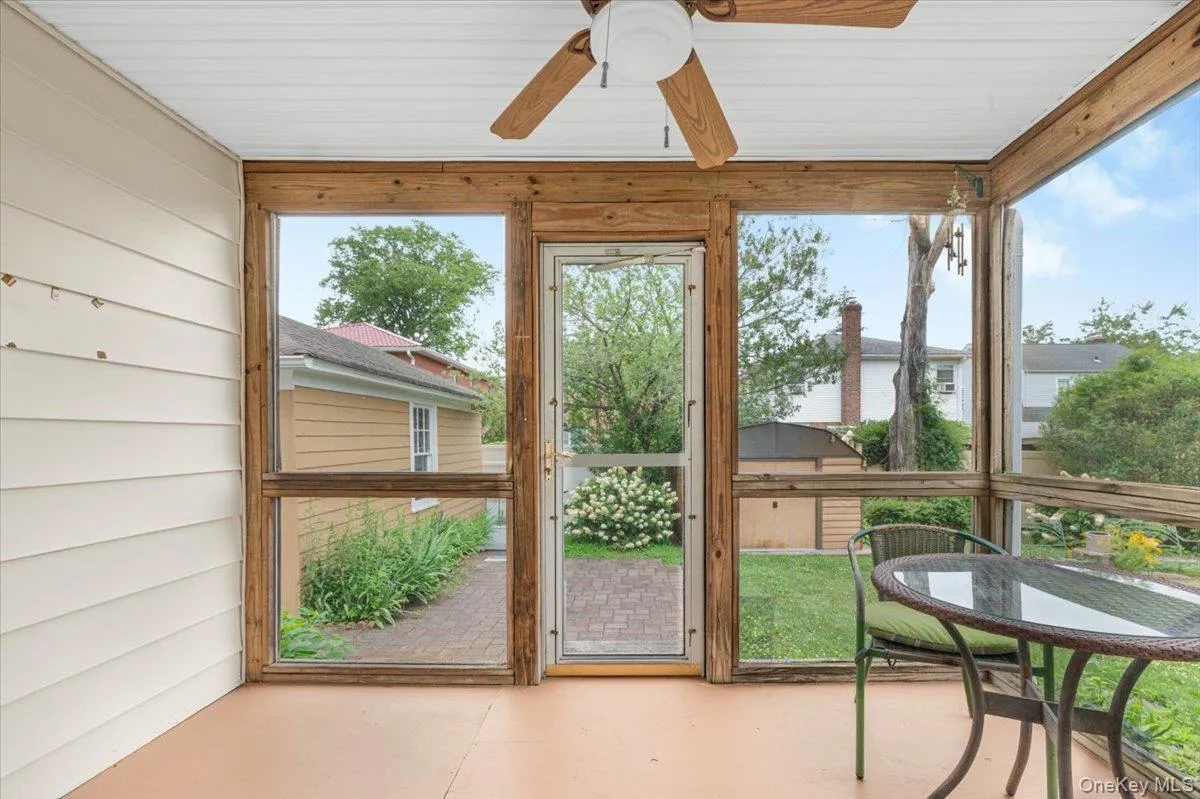Screened porch featuring a paneled ceiling, wood-finish framing, and a ceiling fan Screened porch featuring a paneled ceiling, wood-finish framing, and a ceiling fan