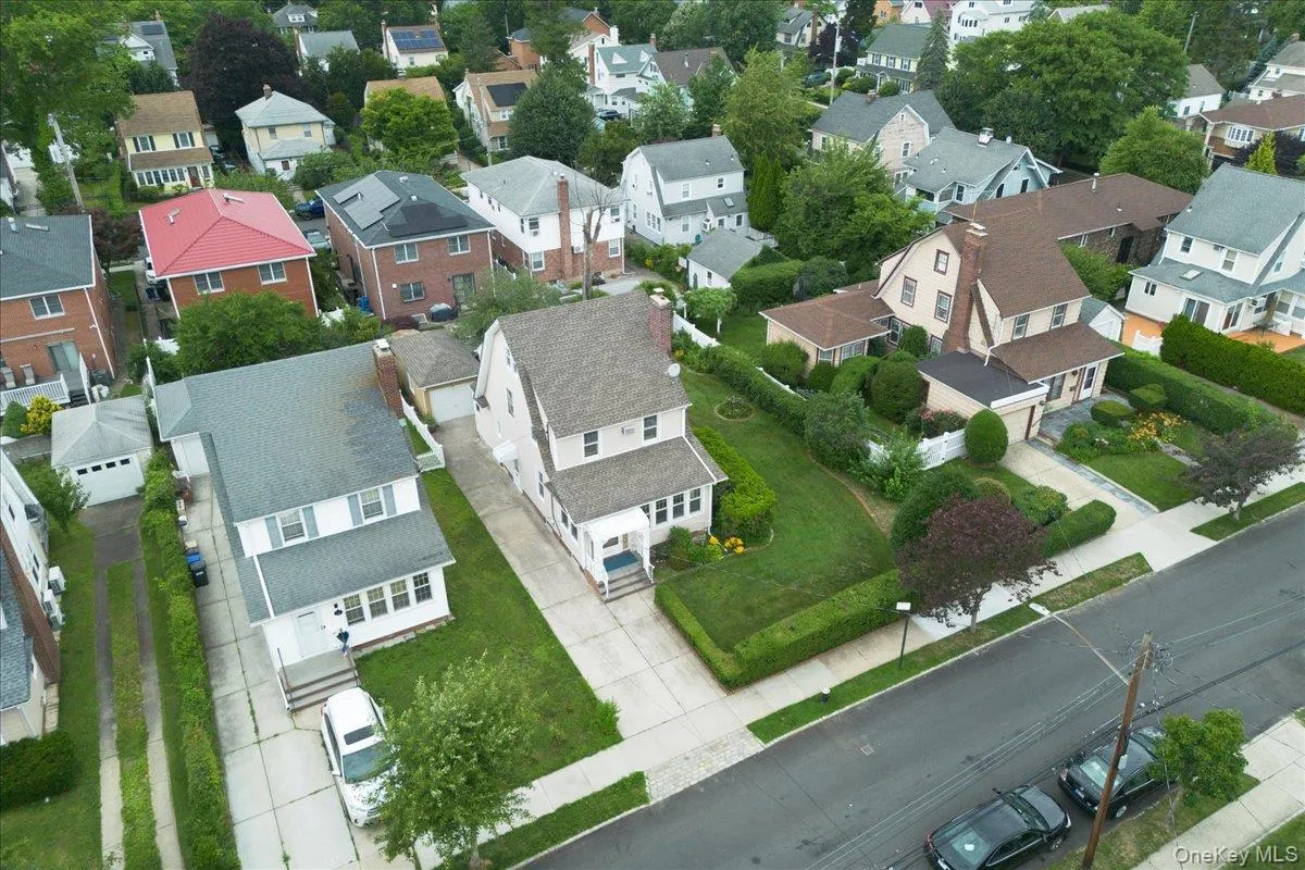 Residential neighborhood featuring a variety of architectural styles, mature trees, manicured lawns, paved driveways, and sidewalks Residential neighborhood featuring a variety of architectural styles, mature trees, manicured lawns, paved driveways, and sidewalks