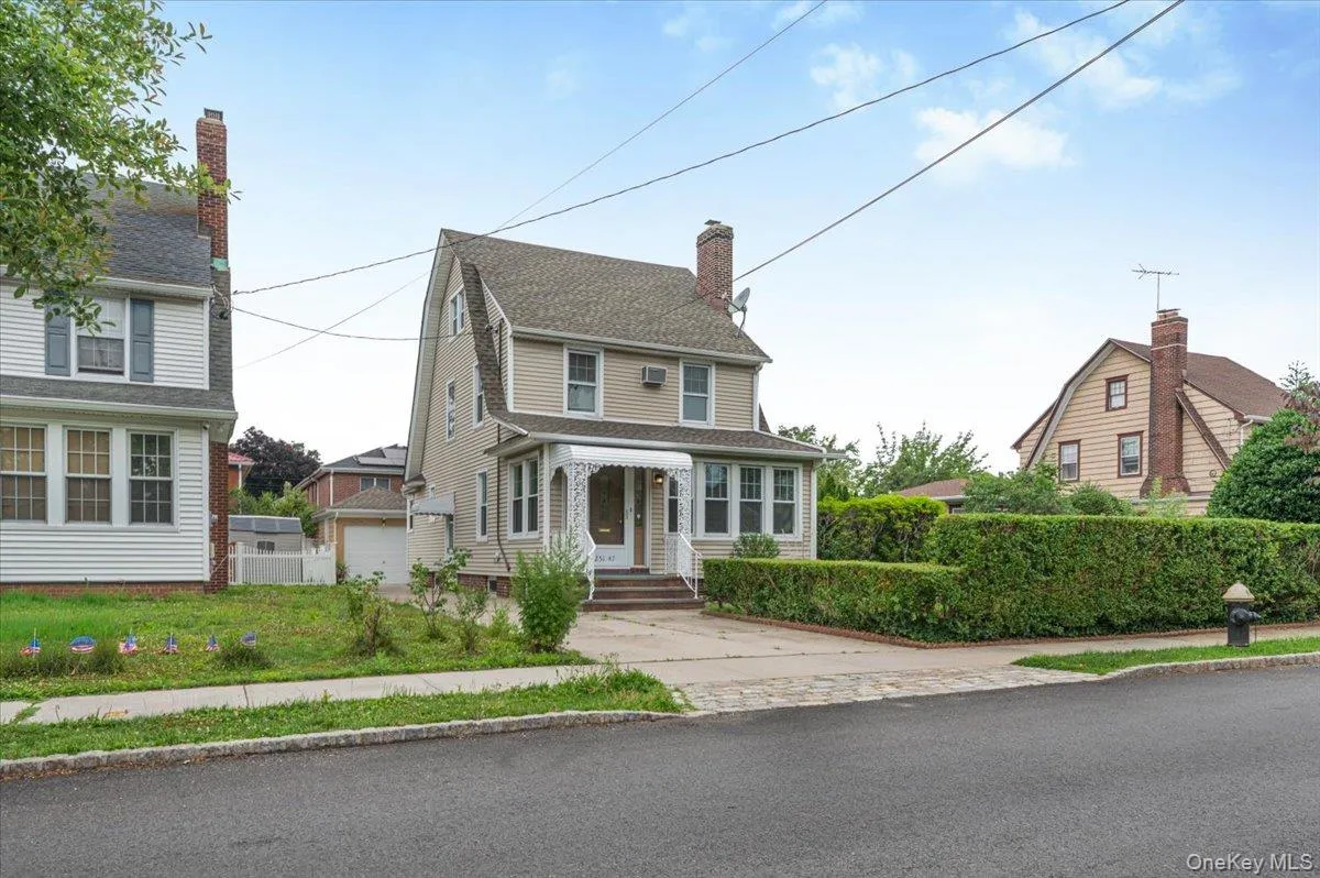 Traditional-style residence featuring light beige siding and a prominent Gambrel roofline Traditional-style residence featuring light beige siding and a prominent Gambrel roofline