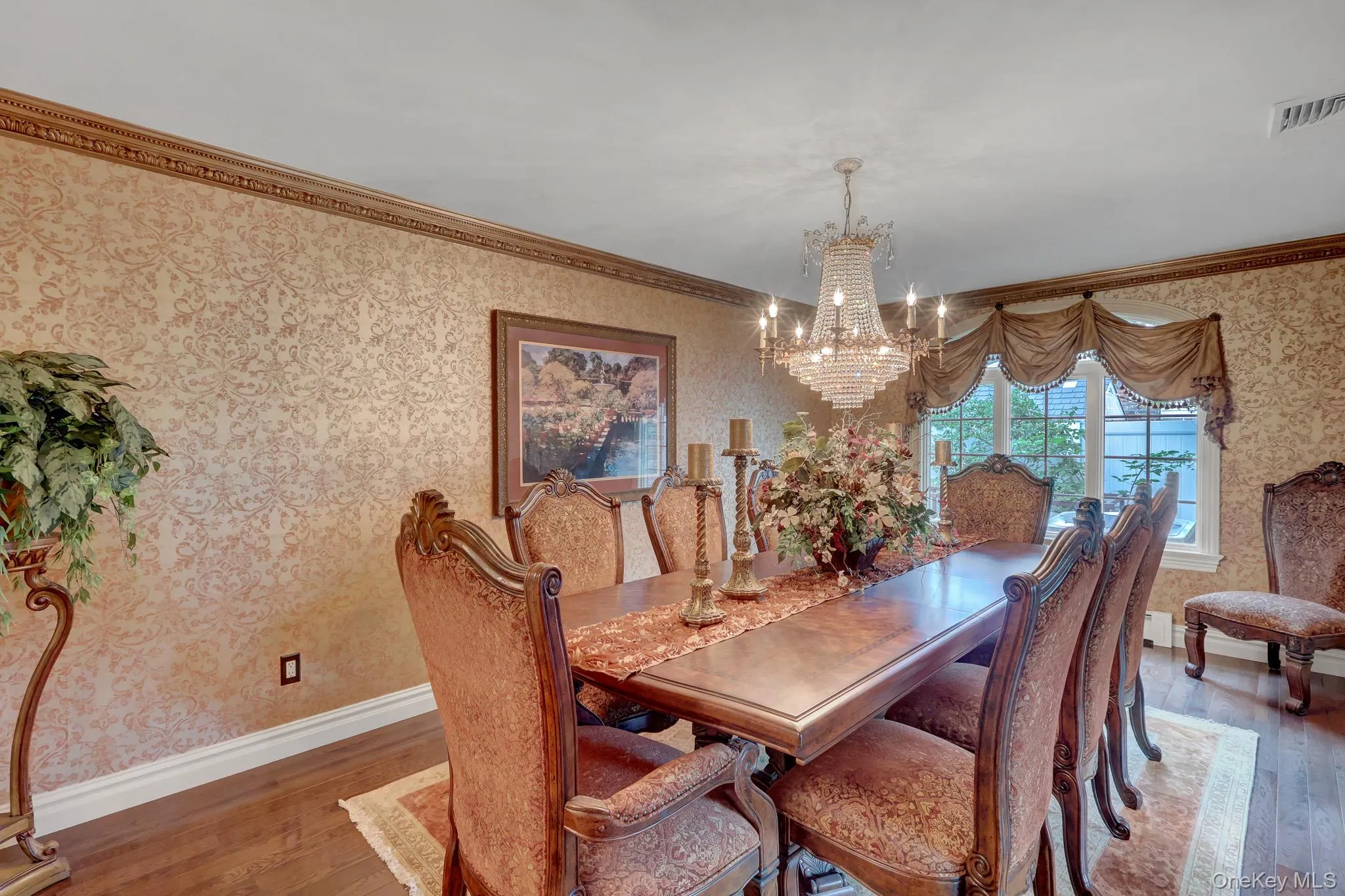 Formal dining space featuring patterned wallpaper and decorative crown molding Formal dining space featuring patterned wallpaper and decorative crown molding
