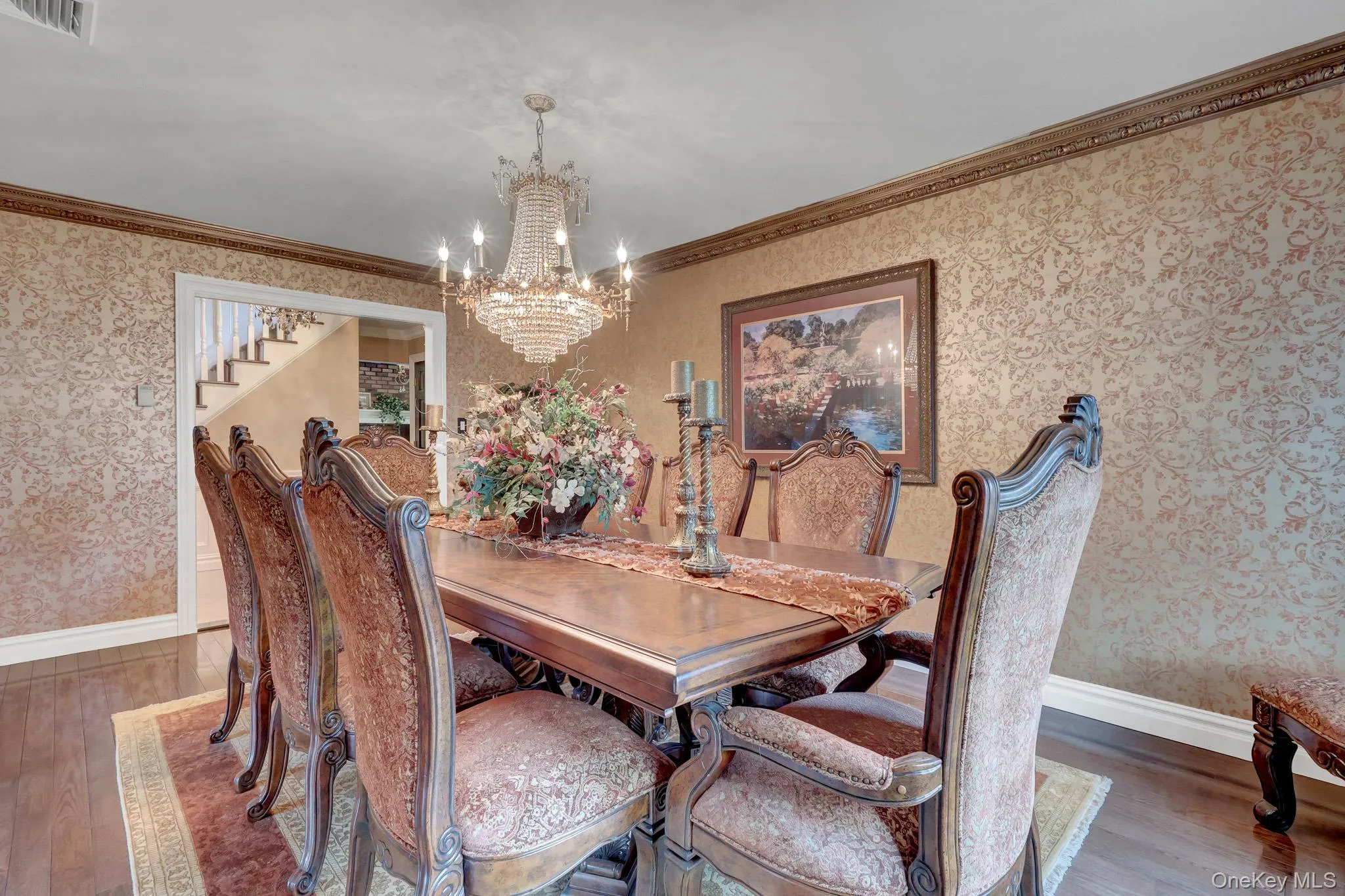 Formal dining room featuring patterned wallpaper and wood-finish flooring Formal dining room featuring patterned wallpaper and wood-finish flooring