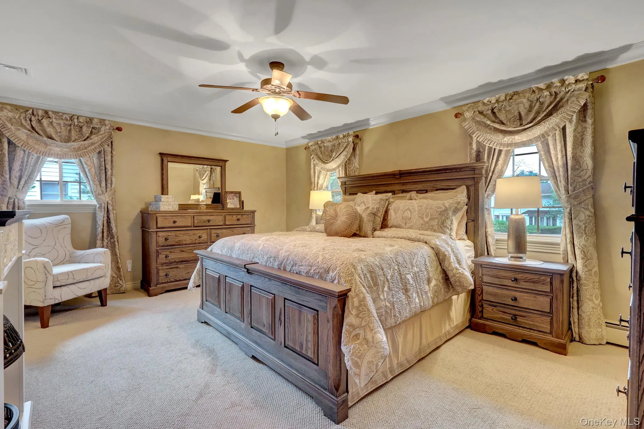 Carpeted bedroom with two windows featuring decorative valances and drapes Carpeted bedroom with two windows featuring decorative valances and drapes