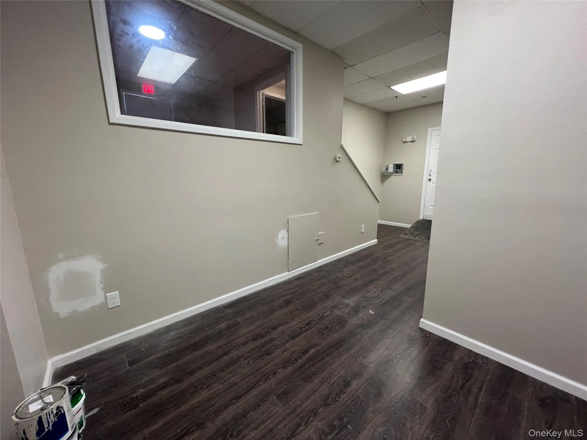 Unfurnished room featuring a paneled ceiling, baseboards, and dark wood finished floors Unfurnished room featuring a paneled ceiling, baseboards, and dark wood finished floors