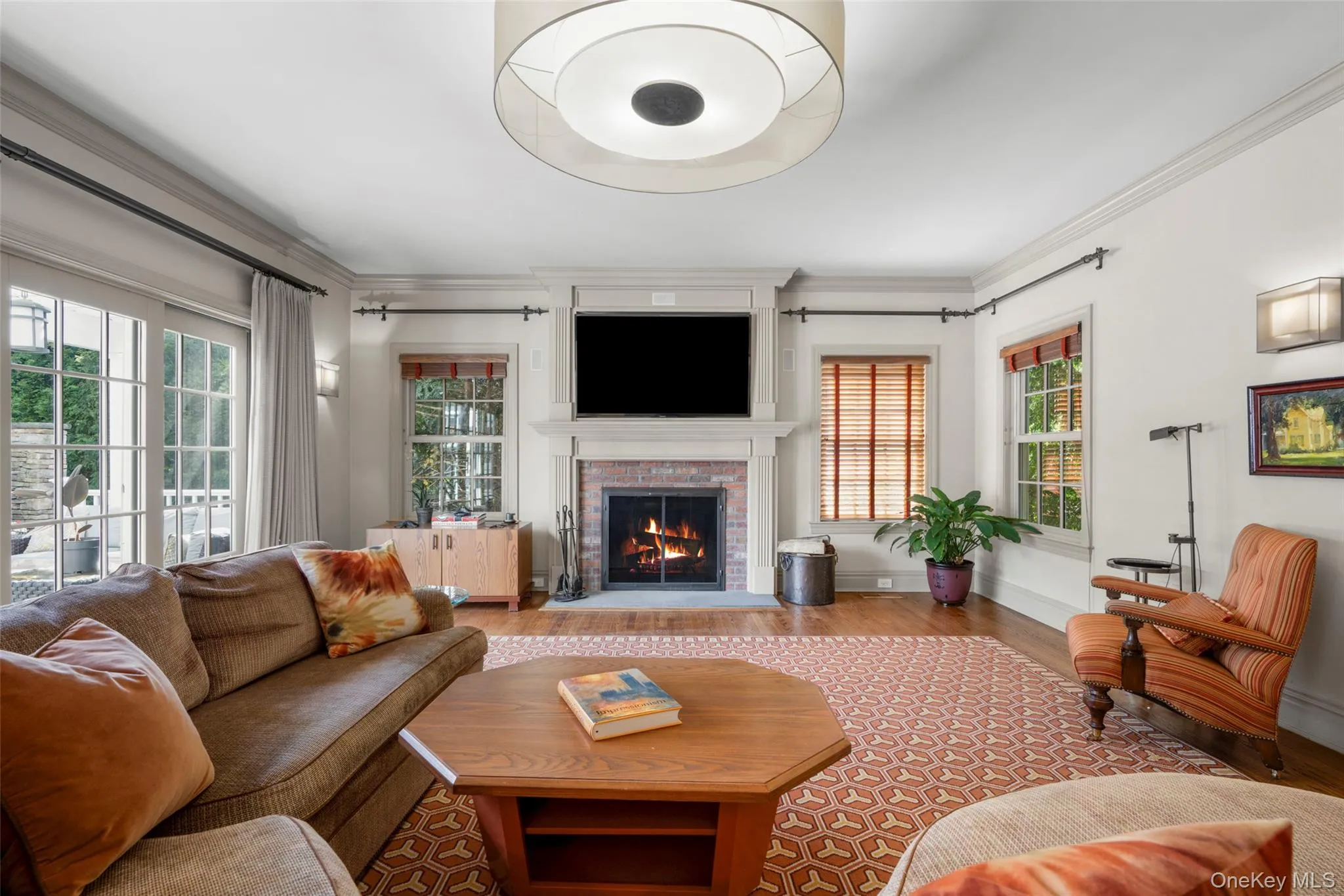 Living room/family room featuring a brick fireplace with sliding glass door leading to the back patio Living room/family room featuring a brick fireplace with sliding glass door leading to the back patio