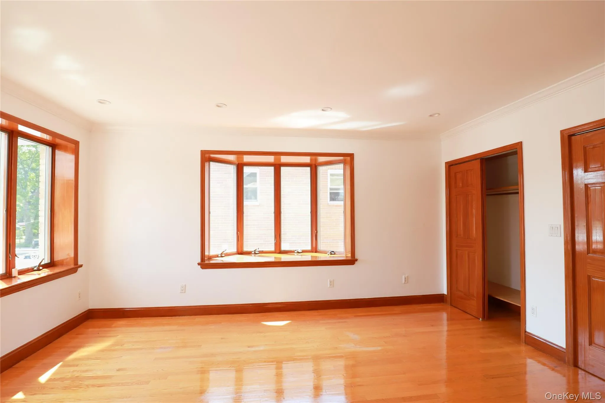 Bright interior space featuring a prominent bay window with wood trim Bright interior space featuring a prominent bay window with wood trim