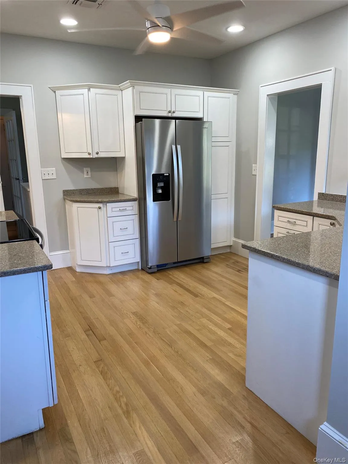 Kitchen with stainless steel fridge, ceiling fan, white cabinetry, recessed lighting, and light wood-style flooring Kitchen with stainless steel fridge, ceiling fan, white cabinetry, recessed lighting, and light wood-style flooring