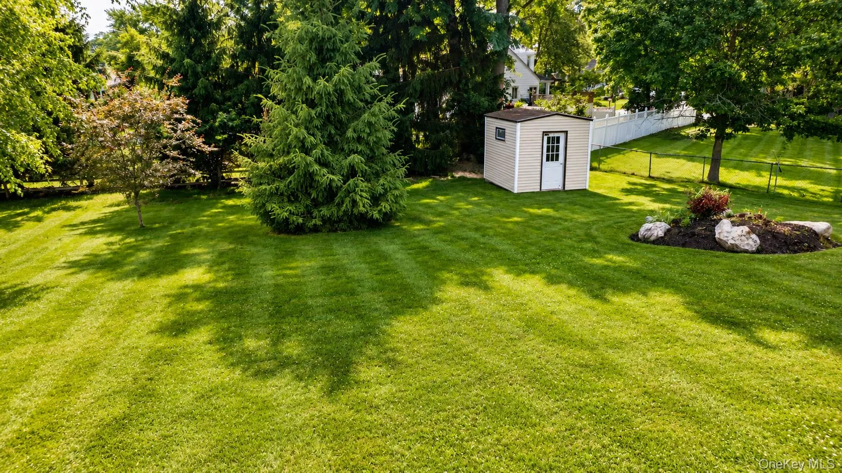 Expansive lawn featuring mature trees and shed. Expansive lawn featuring mature trees and shed.