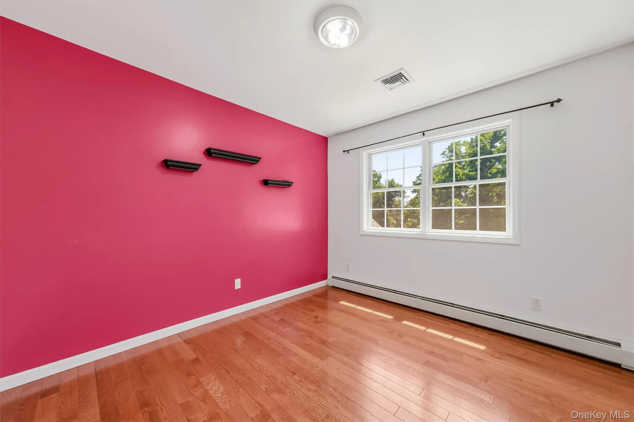 Fourth Bedroom with gleaming hardwood floors and ample closet space Fourth Bedroom with gleaming hardwood floors and ample closet space