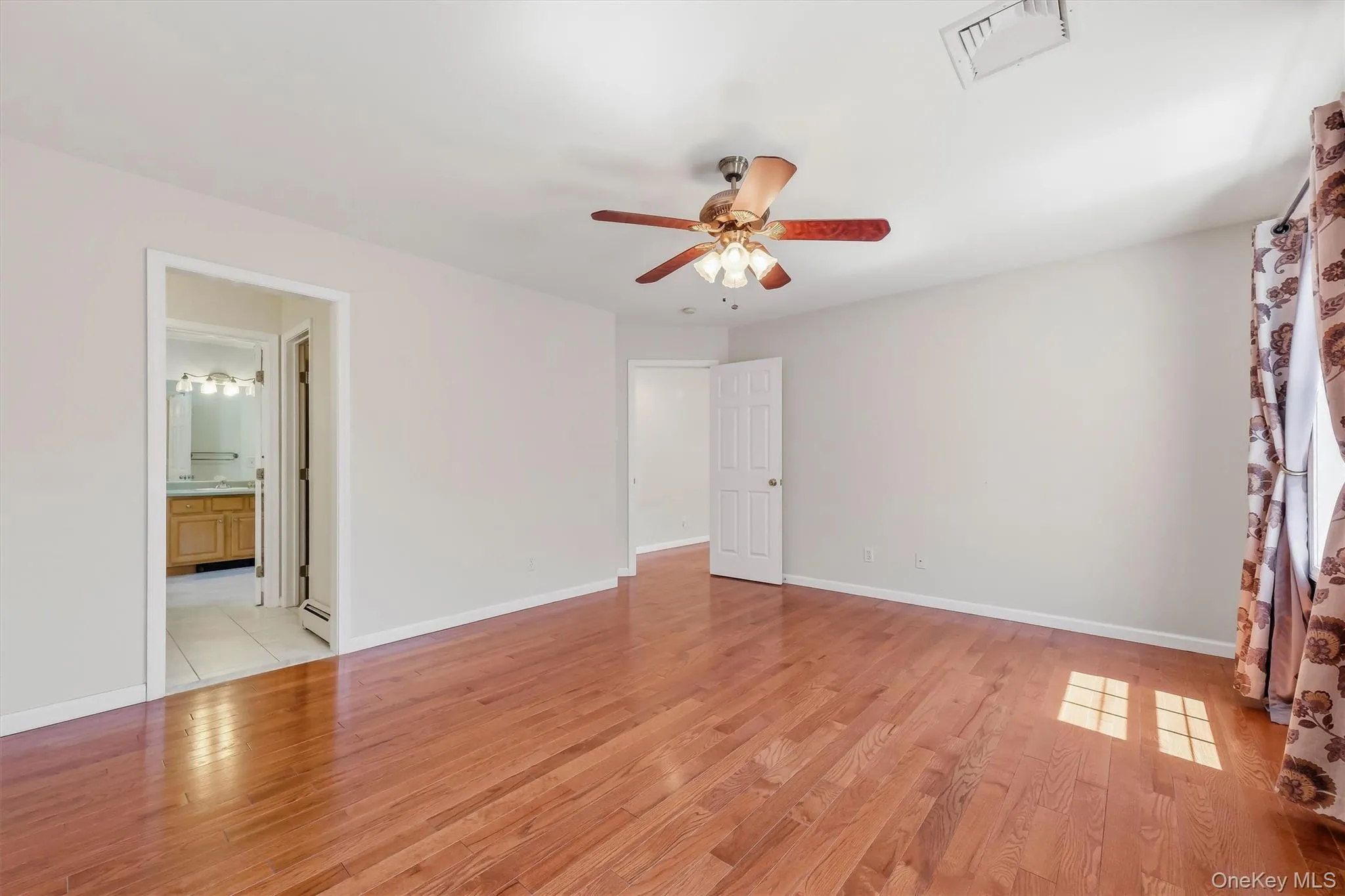 Primary Bedroom with gleaming hardwood floors, private bathroom suite & walk-in closet Primary Bedroom with gleaming hardwood floors, private bathroom suite & walk-in closet