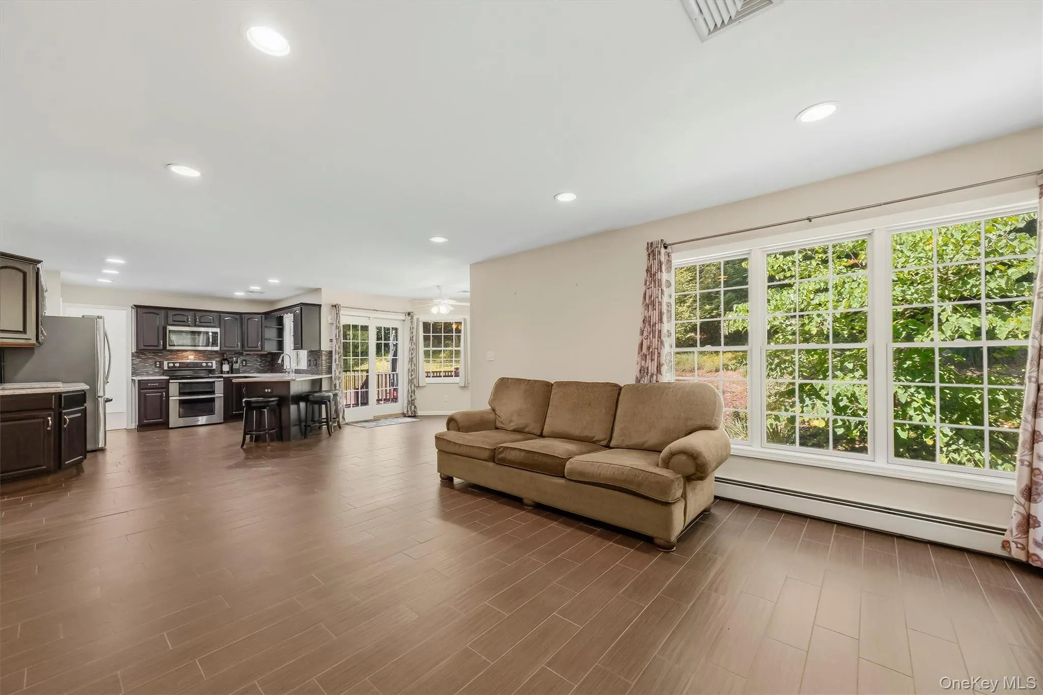 Sitting room off kitchen with expansive windows & ornate wood burning stove Sitting room off kitchen with expansive windows & ornate wood burning stove