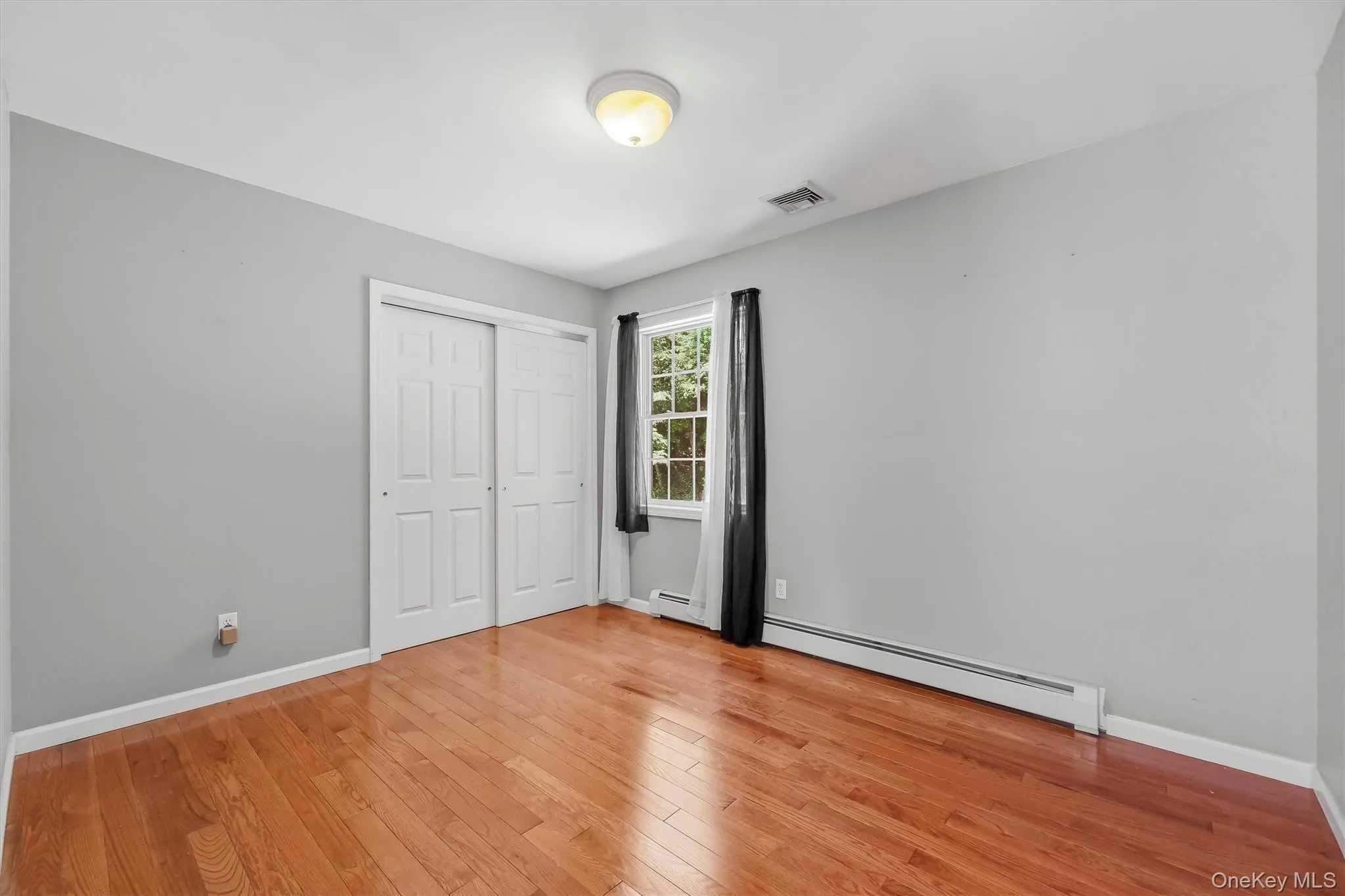 Second Bedroom with gleaming hardwood floors and ample closet space Second Bedroom with gleaming hardwood floors and ample closet space