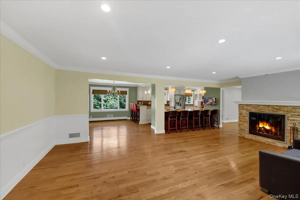 Living room with wainscoting, fire-place & hardwood floors Living room with wainscoting, fire-place & hardwood floors