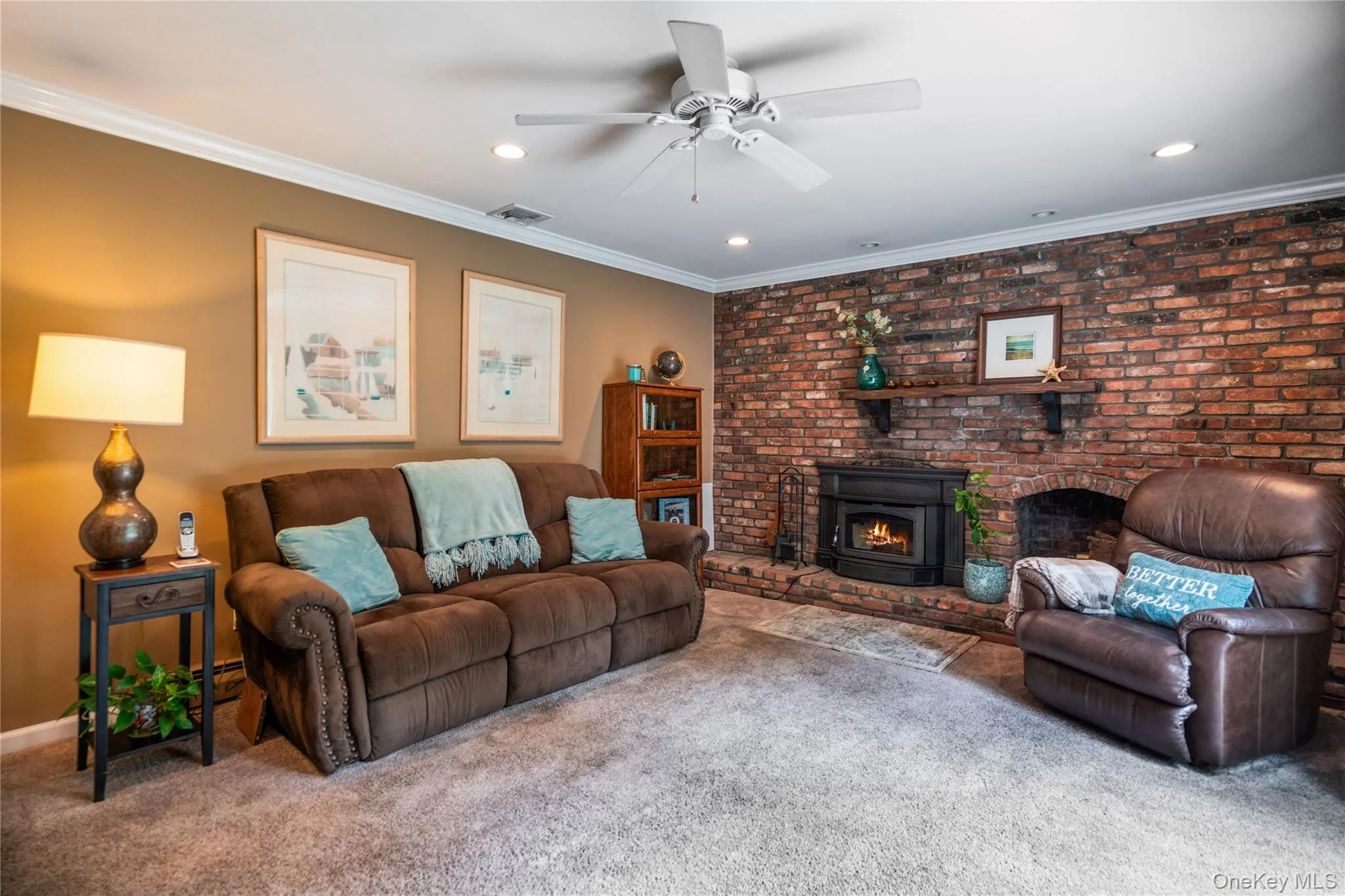 Living area featuring a prominent brick accent wall with a built-in fireplace insert Living area featuring a prominent brick accent wall with a built-in fireplace insert