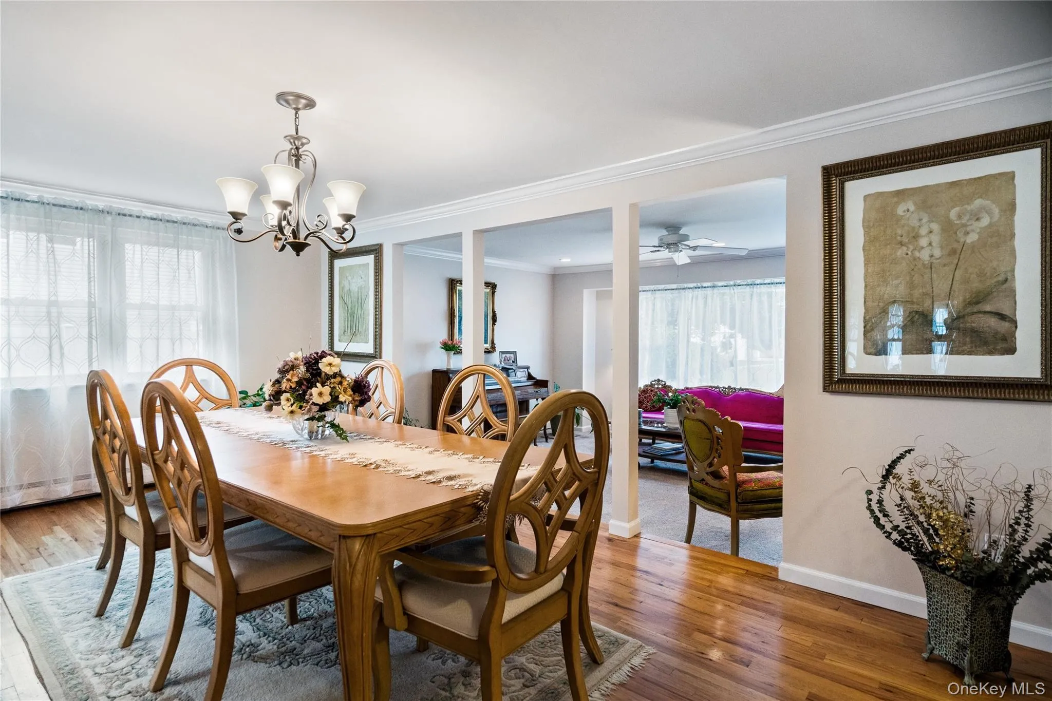 Dining area featuring wood-finish flooring, a decorative area rug, and a brushed nickel chandelier Dining area featuring wood-finish flooring, a decorative area rug, and a brushed nickel chandelier