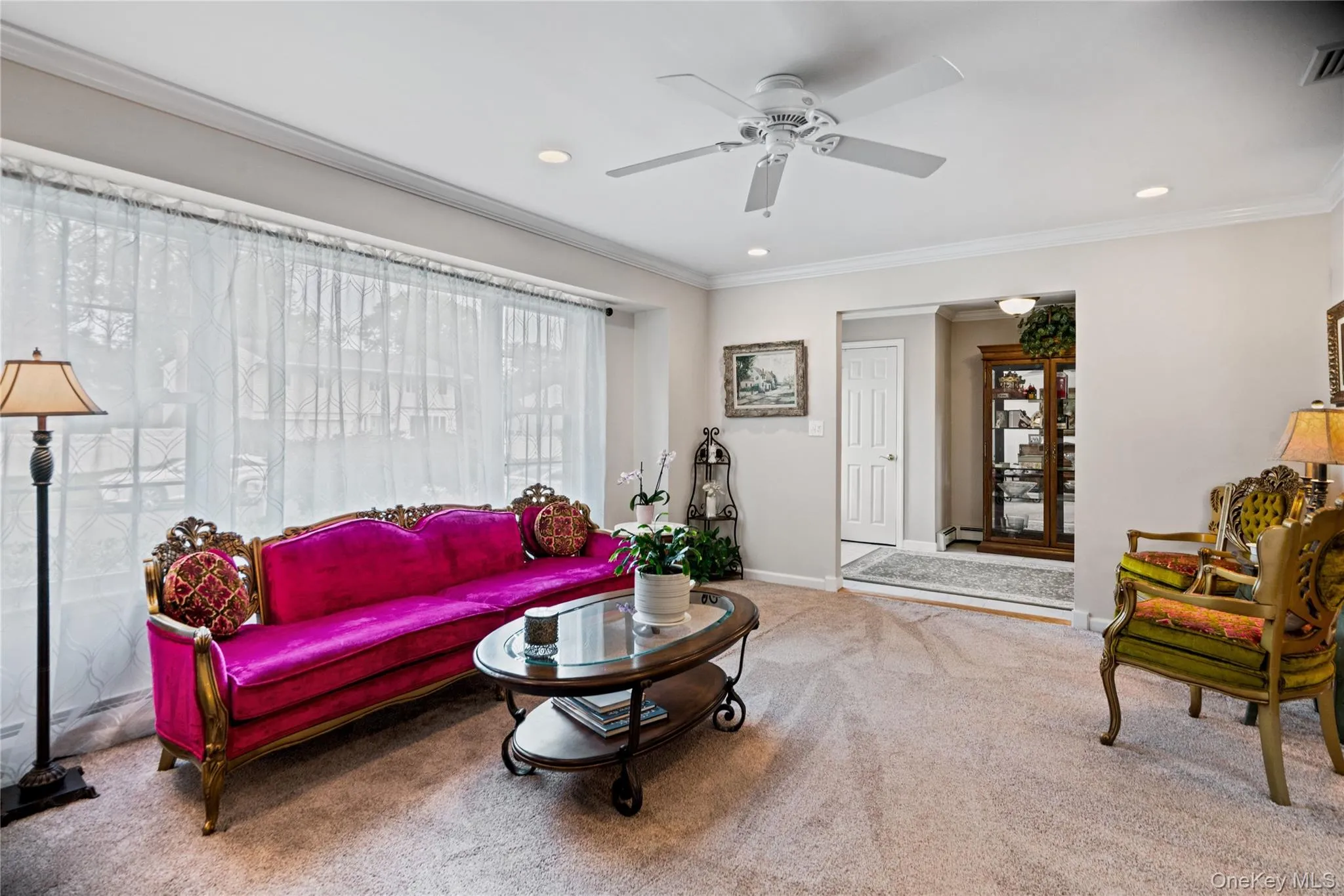 Living area featuring a large picture window with sheer drapery, recessed lighting, and a ceiling fan Living area featuring a large picture window with sheer drapery, recessed lighting, and a ceiling fan