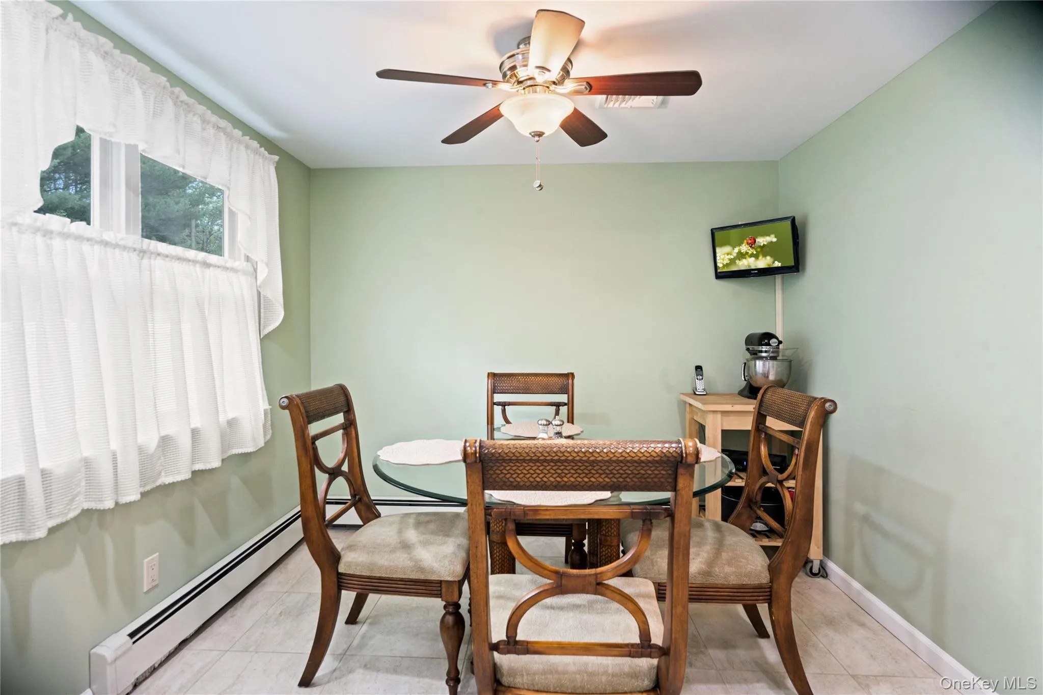 Dining area featuring light green walls, a ceiling fan with integrated lighting, and tile flooring Dining area featuring light green walls, a ceiling fan with integrated lighting, and tile flooring