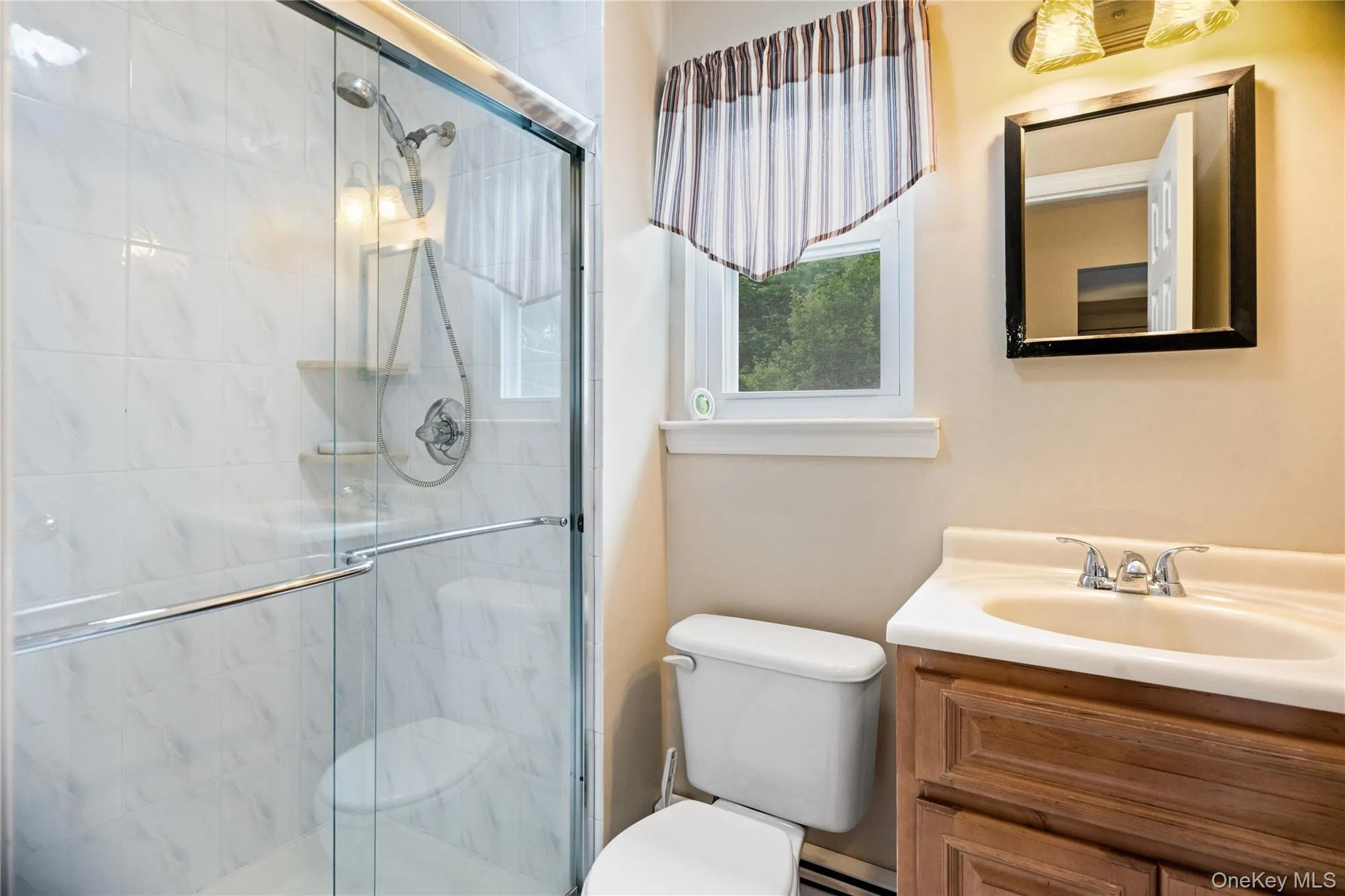Frameless glass shower enclosure with white tiled walls and integrated shelving Frameless glass shower enclosure with white tiled walls and integrated shelving