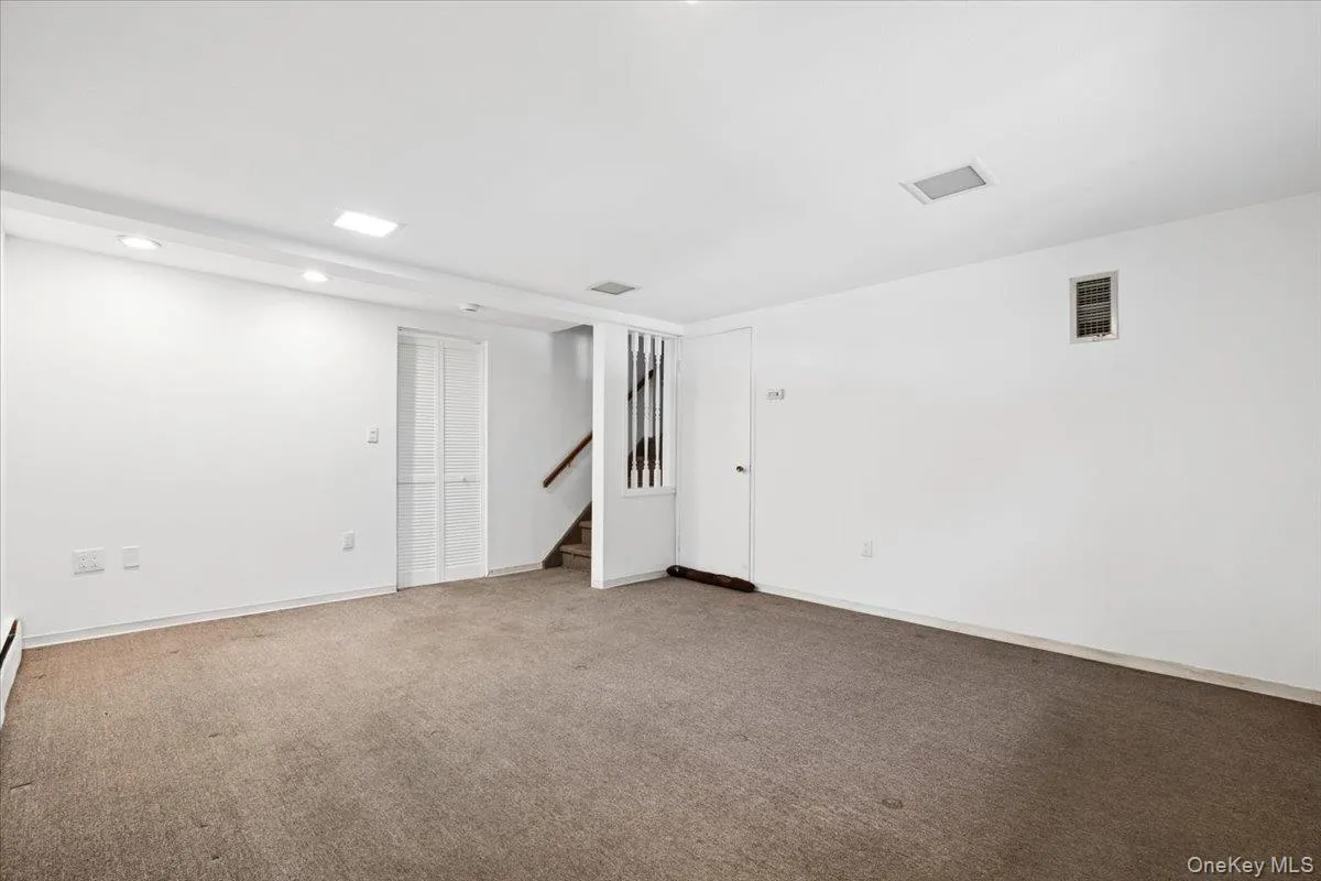 Head down from the kitchen to a lower level den. The door to the right of the stairs provides access to the crawl space. The louver door heads to mechanicals, laundry hook-up and a half bath. Head down from the kitchen to a lower level den. The door to the right of the stairs provides access to the crawl space. The louver door heads to mechanicals, laundry hook-up and a half bath.