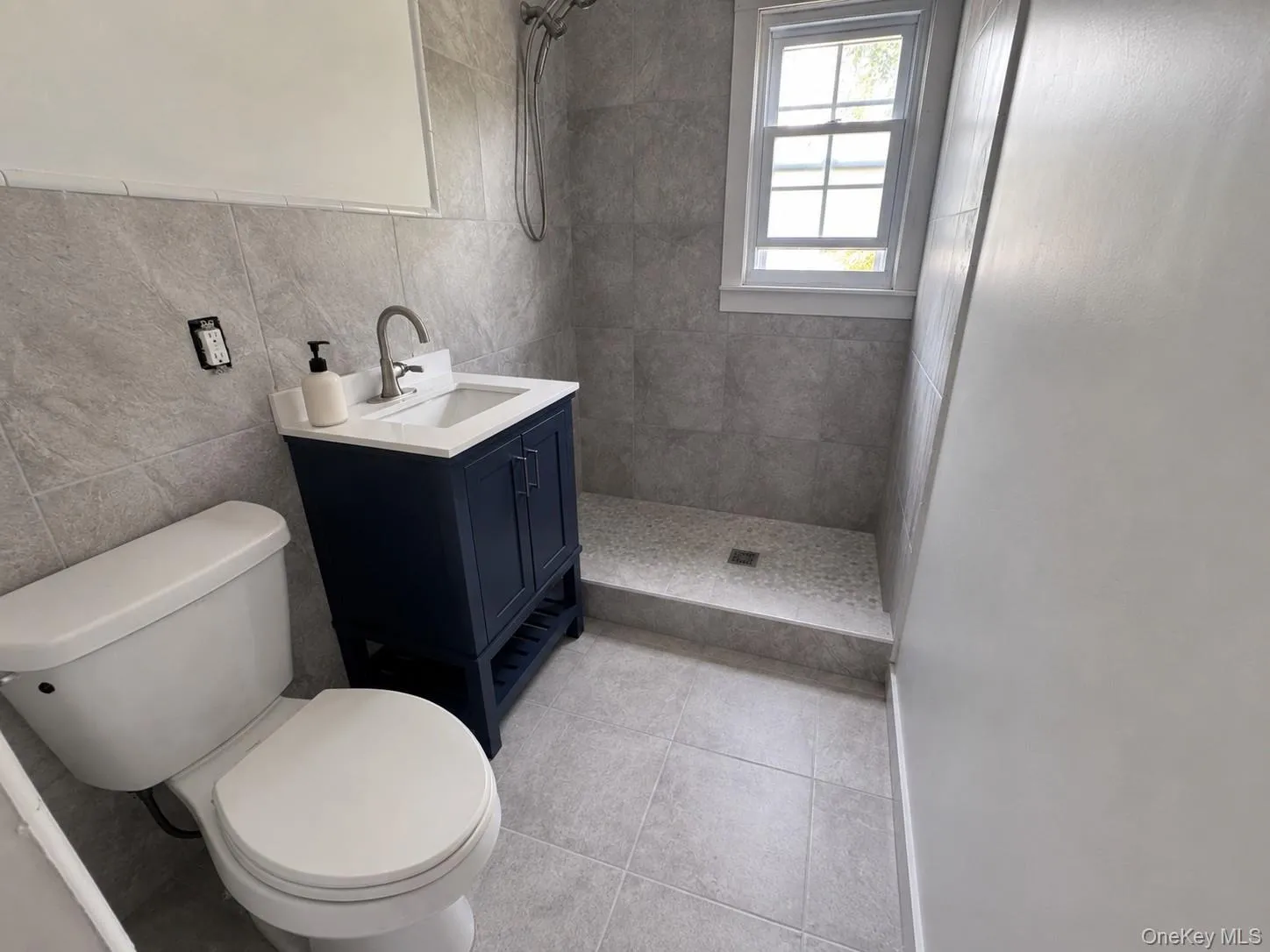 First floor full bath (floor tile virtually added). First floor full bath (floor tile virtually added).