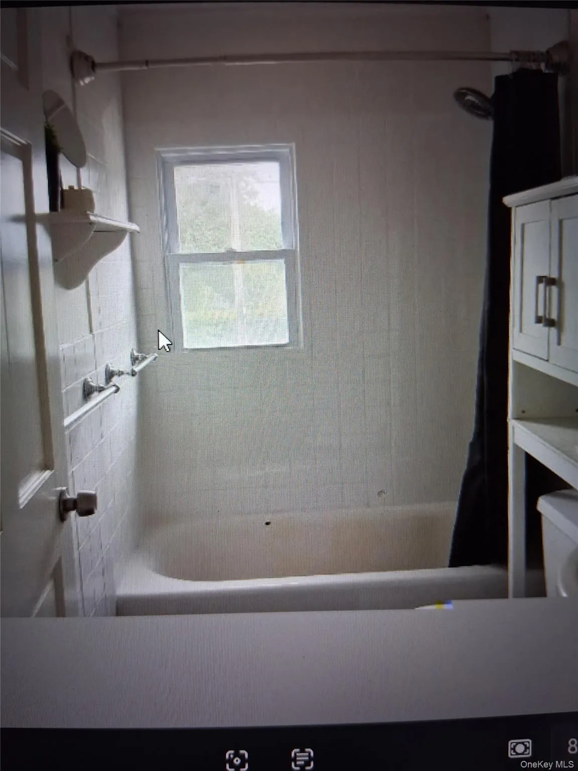 Bathtub with white tile surround and a window above Bathtub with white tile surround and a window above