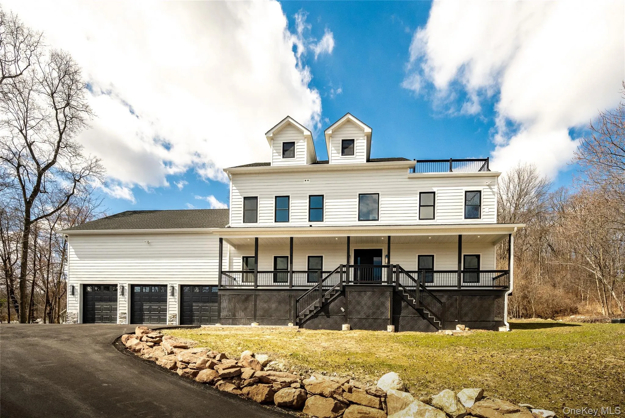 Contemporary Hardie Plank white siding exterior with a multi-level porch, black railings, and a 6-car garage Contemporary Hardie Plank white siding exterior with a multi-level porch, black railings, and a 6-car garage