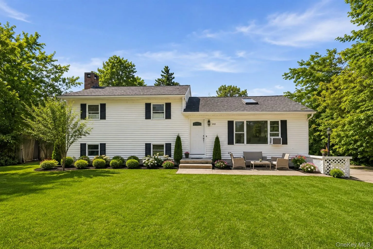 White siding exterior with black shutters and a black shingle roof White siding exterior with black shutters and a black shingle roof