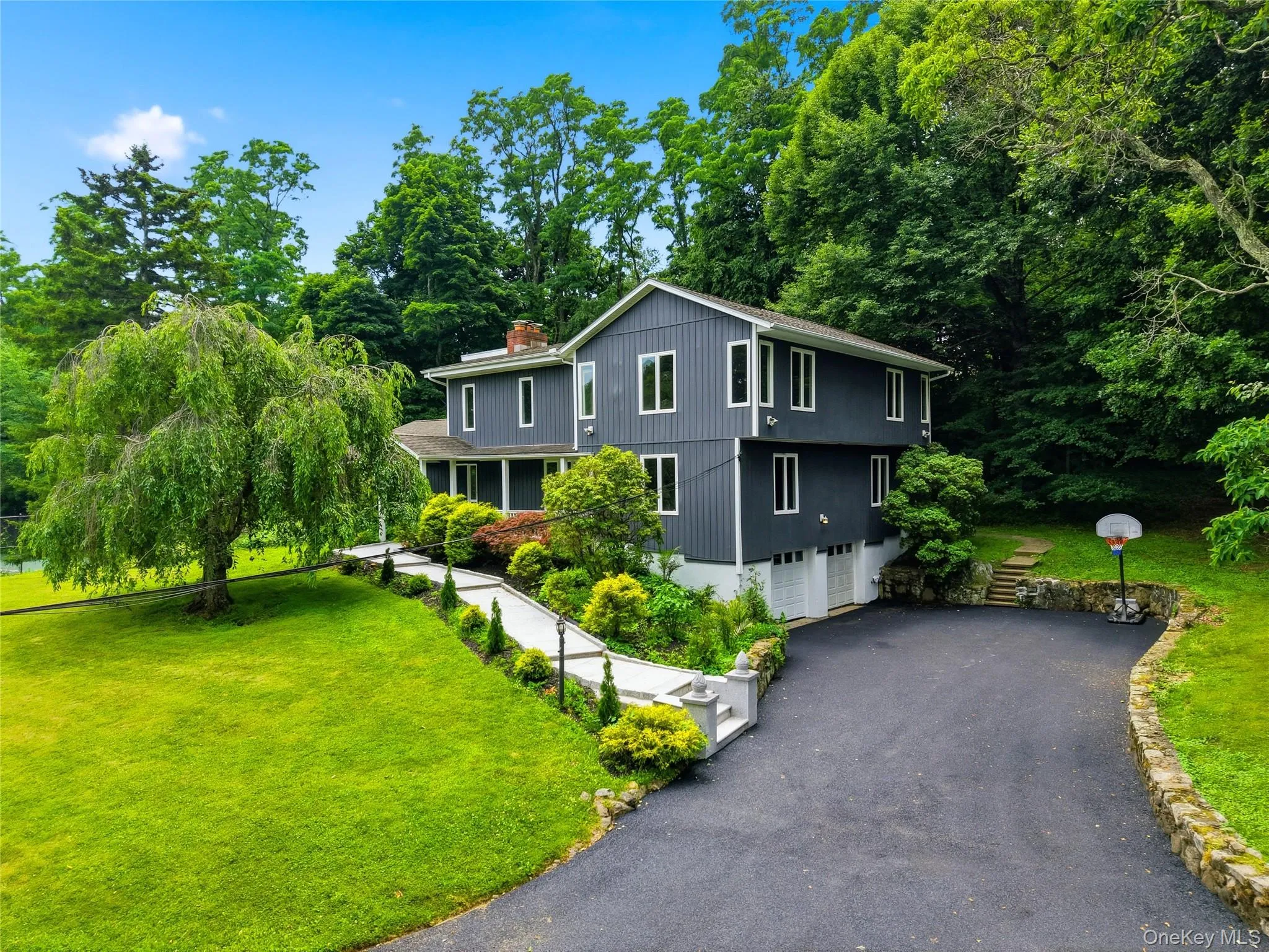 Contemporary split-level residence featuring dark gray siding and white trim Contemporary split-level residence featuring dark gray siding and white trim