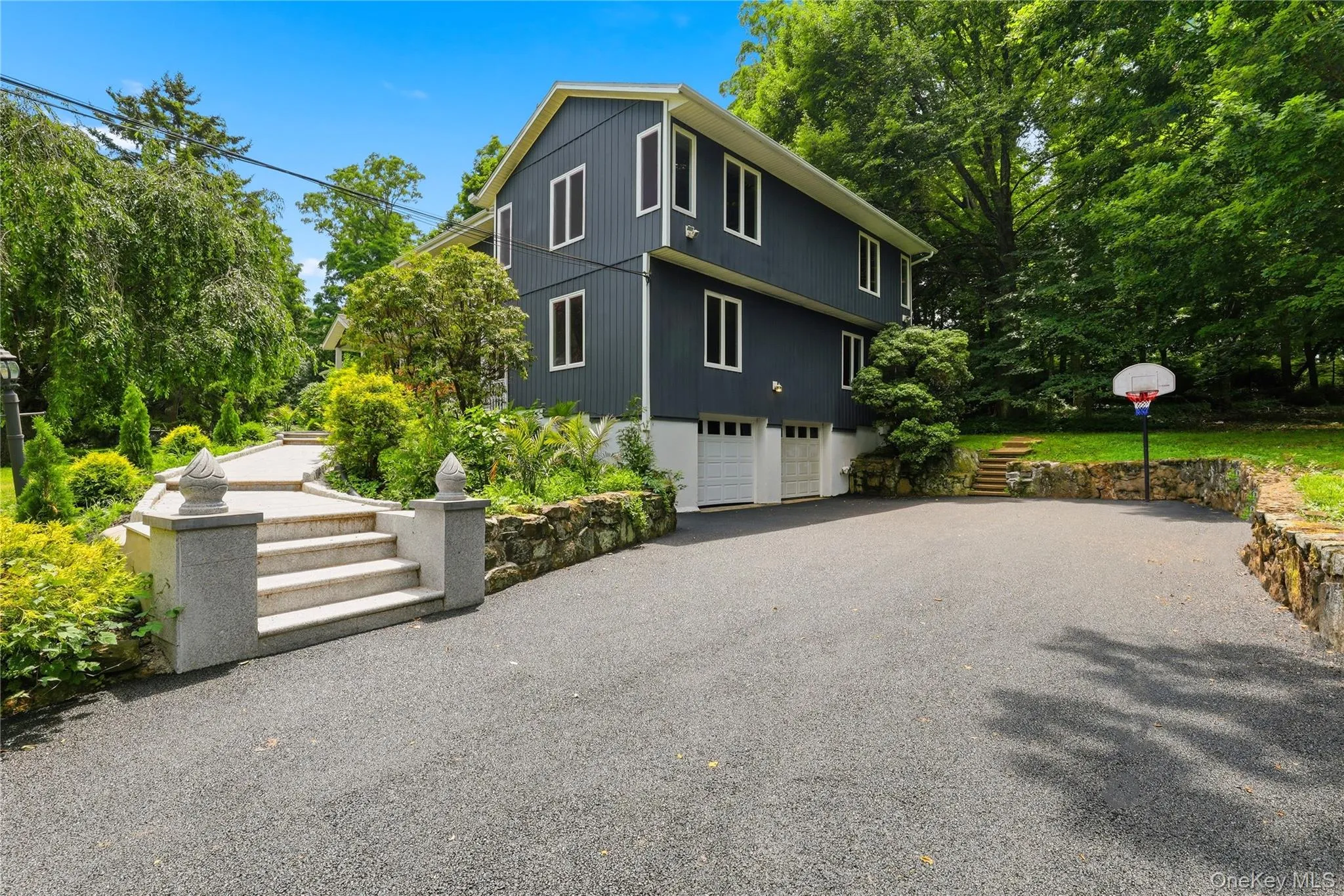 Driveway, 2 car garage with basketball hoop, stairs up to front porch/entry into home. Driveway, 2 car garage with basketball hoop, stairs up to front porch/entry into home.