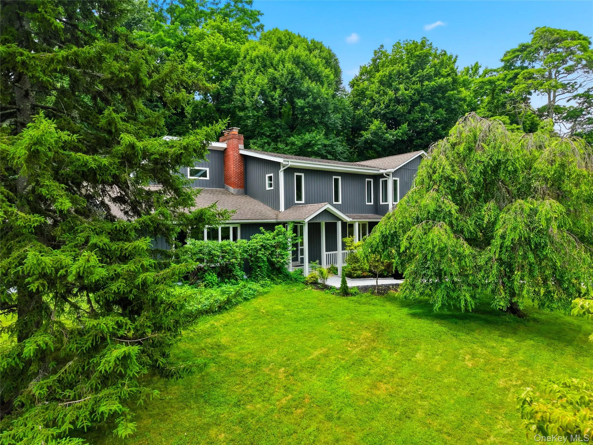 Gray siding residence featuring a prominent red brick chimney Gray siding residence featuring a prominent red brick chimney