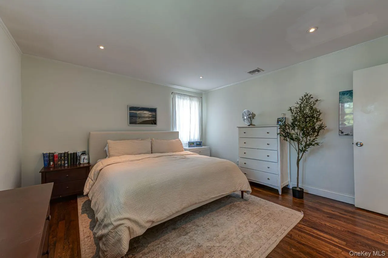 Primary bedroom with hardwood floors and spacious closet space Primary bedroom with hardwood floors and spacious closet space