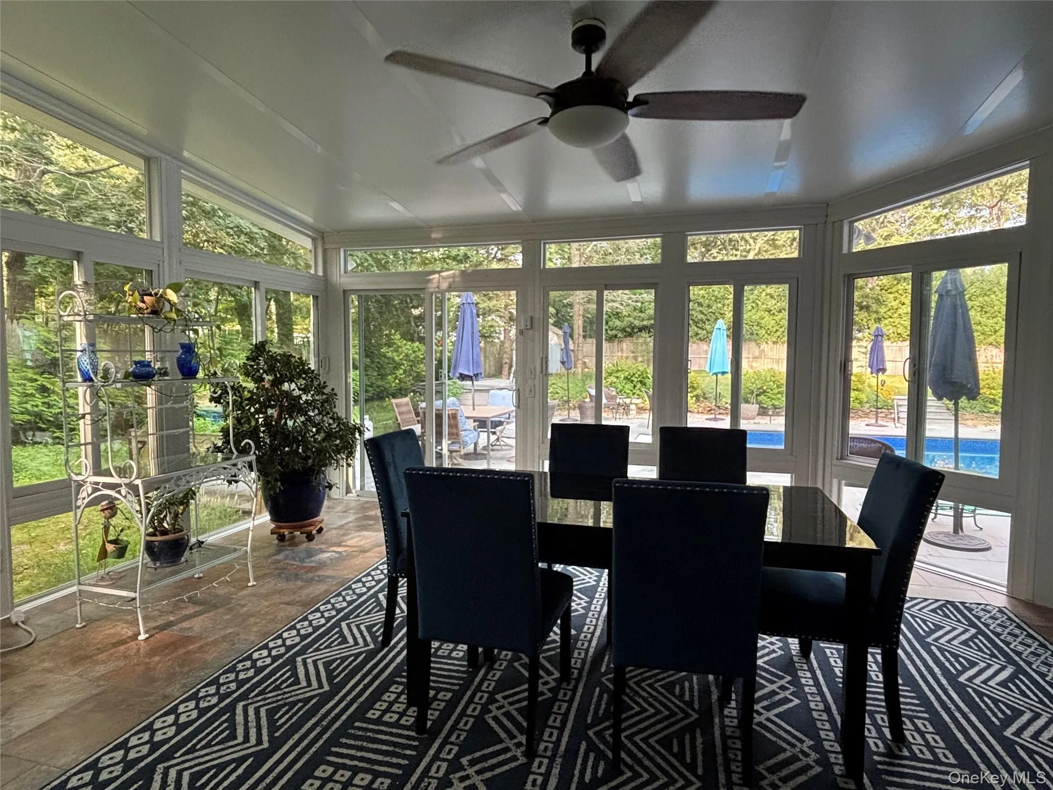 Sun room with extensive window panels, vaulted ceiling, Tiled flooring, a ceiling fan & A/C Unit Sun room with extensive window panels, vaulted ceiling, Tiled flooring, a ceiling fan & A/C Unit