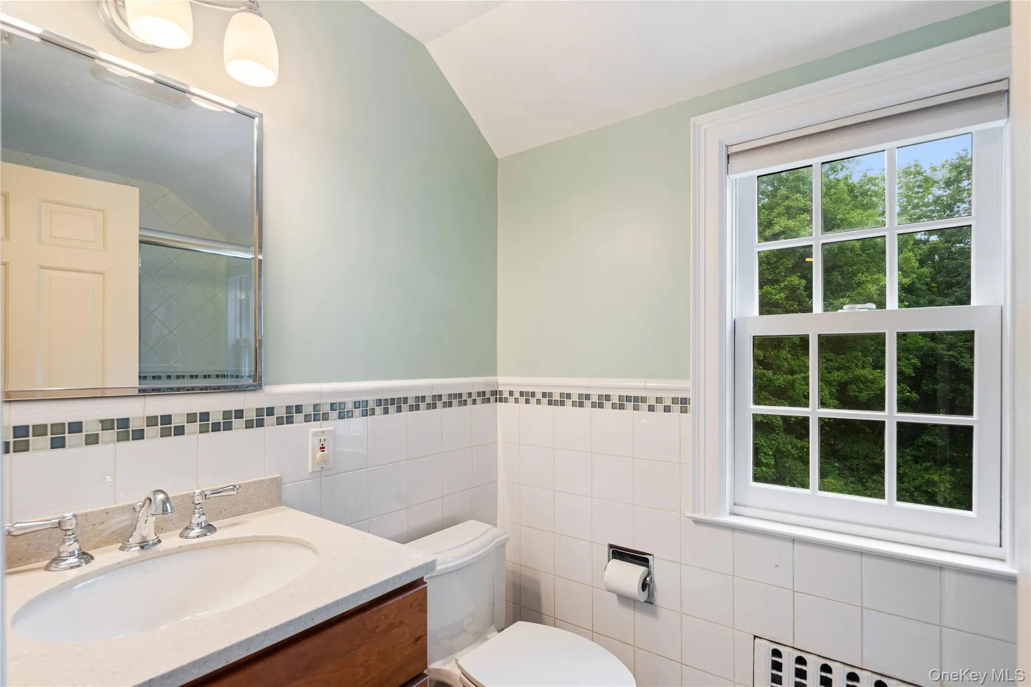 Renovated hall bath, ceramic tile surround with inset glass tile border, full tub with glass doors and Rohl shower hear, storage vanity with undermount sink and wall sconce Renovated hall bath, ceramic tile surround with inset glass tile border, full tub with glass doors and Rohl shower hear, storage vanity with undermount sink and wall sconce