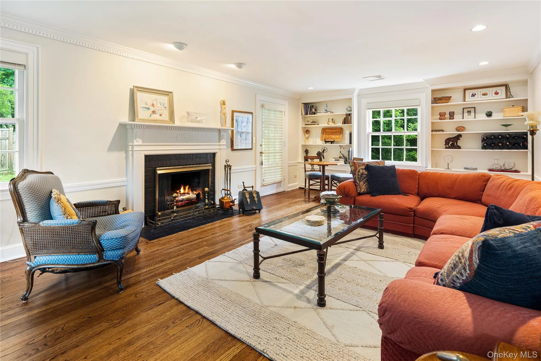 Front to back formal living room, oak floors, new windows, fireplace, window seat, crown molding, recessed lighting, built-in cupboards with shelving above Front to back formal living room, oak floors, new windows, fireplace, window seat, crown molding, recessed lighting, built-in cupboards with shelving above