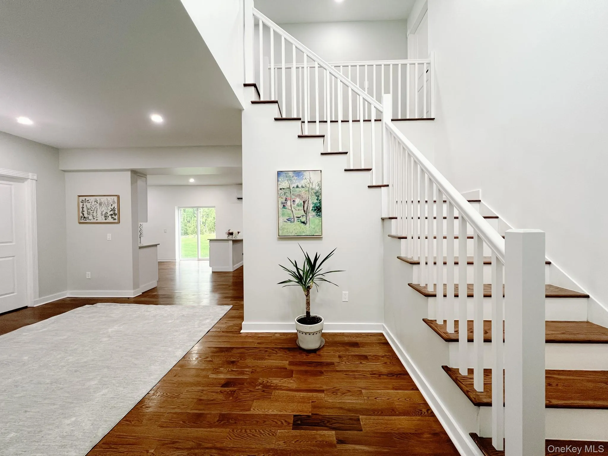 Grand entryway featuring a staircase with white balusters and wood-finish treads Grand entryway featuring a staircase with white balusters and wood-finish treads