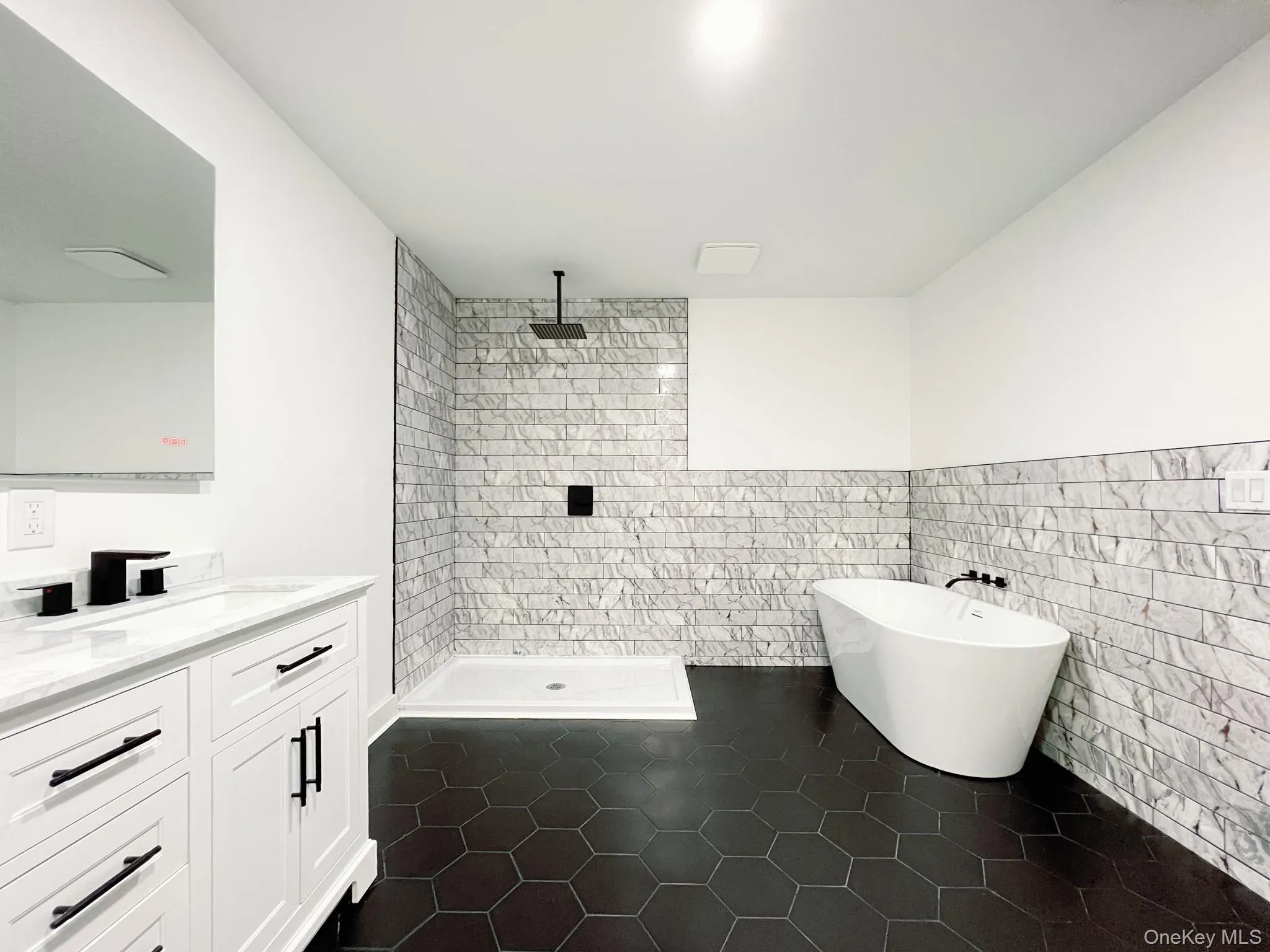 Modern ensuite bathroom featuring a freestanding tub, walk-in shower with rain head, and white vanity with a marble-finish countertop Modern ensuite bathroom featuring a freestanding tub, walk-in shower with rain head, and white vanity with a marble-finish countertop