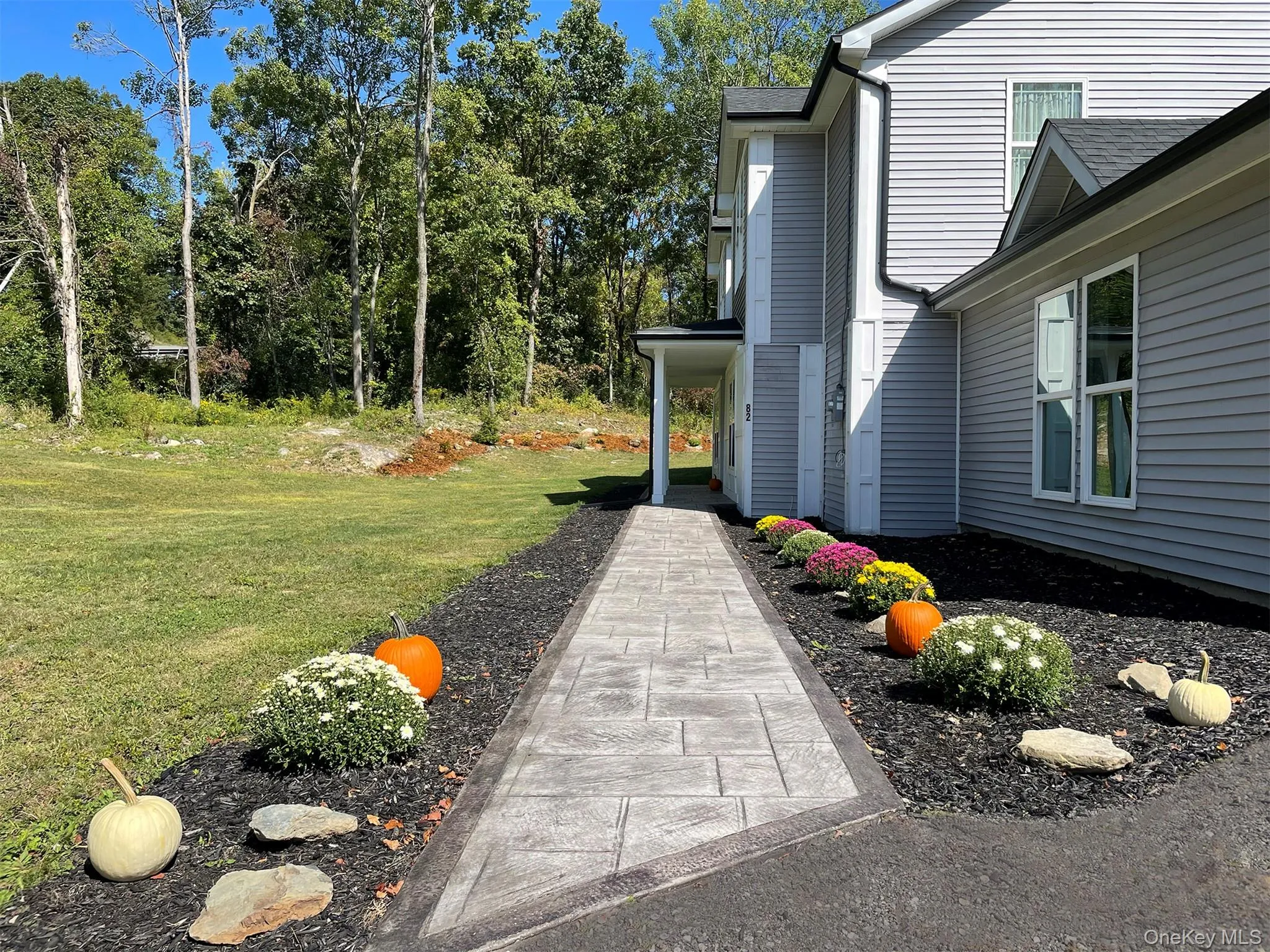 Stone pathway leads to front entrance, lined with flowers Stone pathway leads to front entrance, lined with flowers