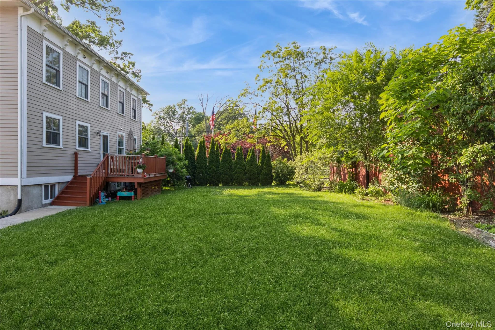 View of green lawn with a deck and stairway View of green lawn with a deck and stairway