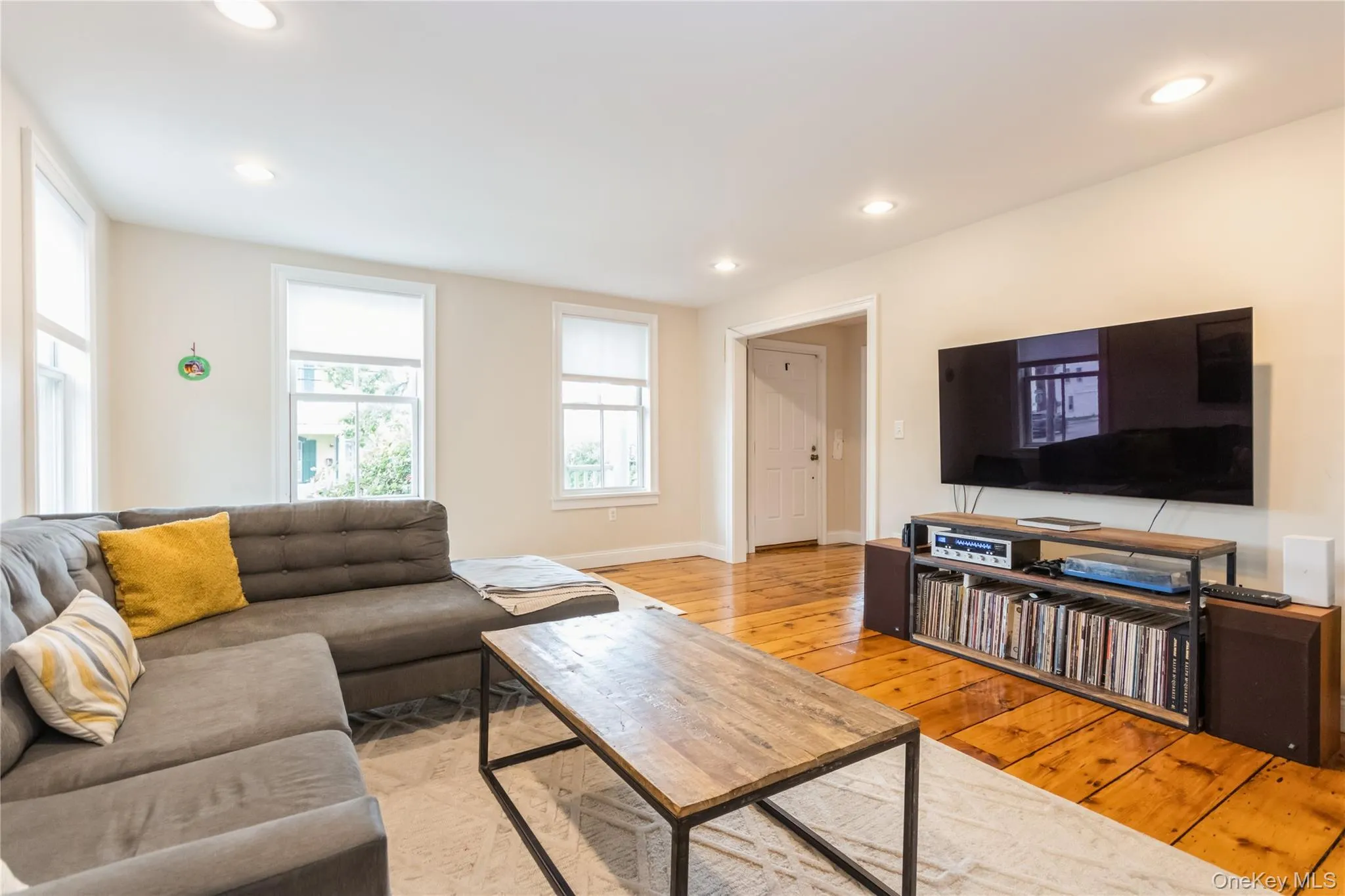 Living room featuring light wood-style flooring and recessed lighting Living room featuring light wood-style flooring and recessed lighting