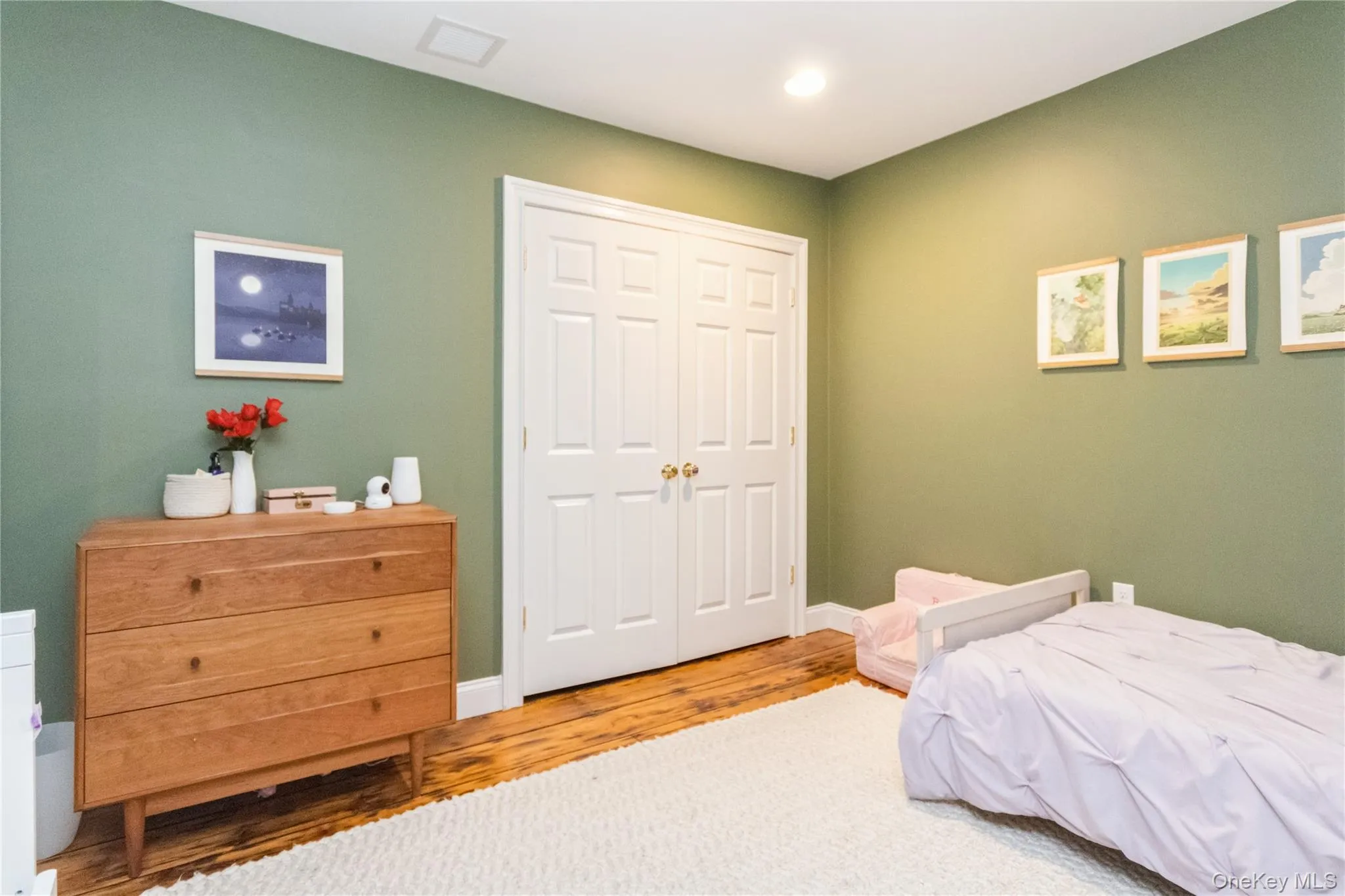Bedroom with wood finished floors and a closet Bedroom with wood finished floors and a closet