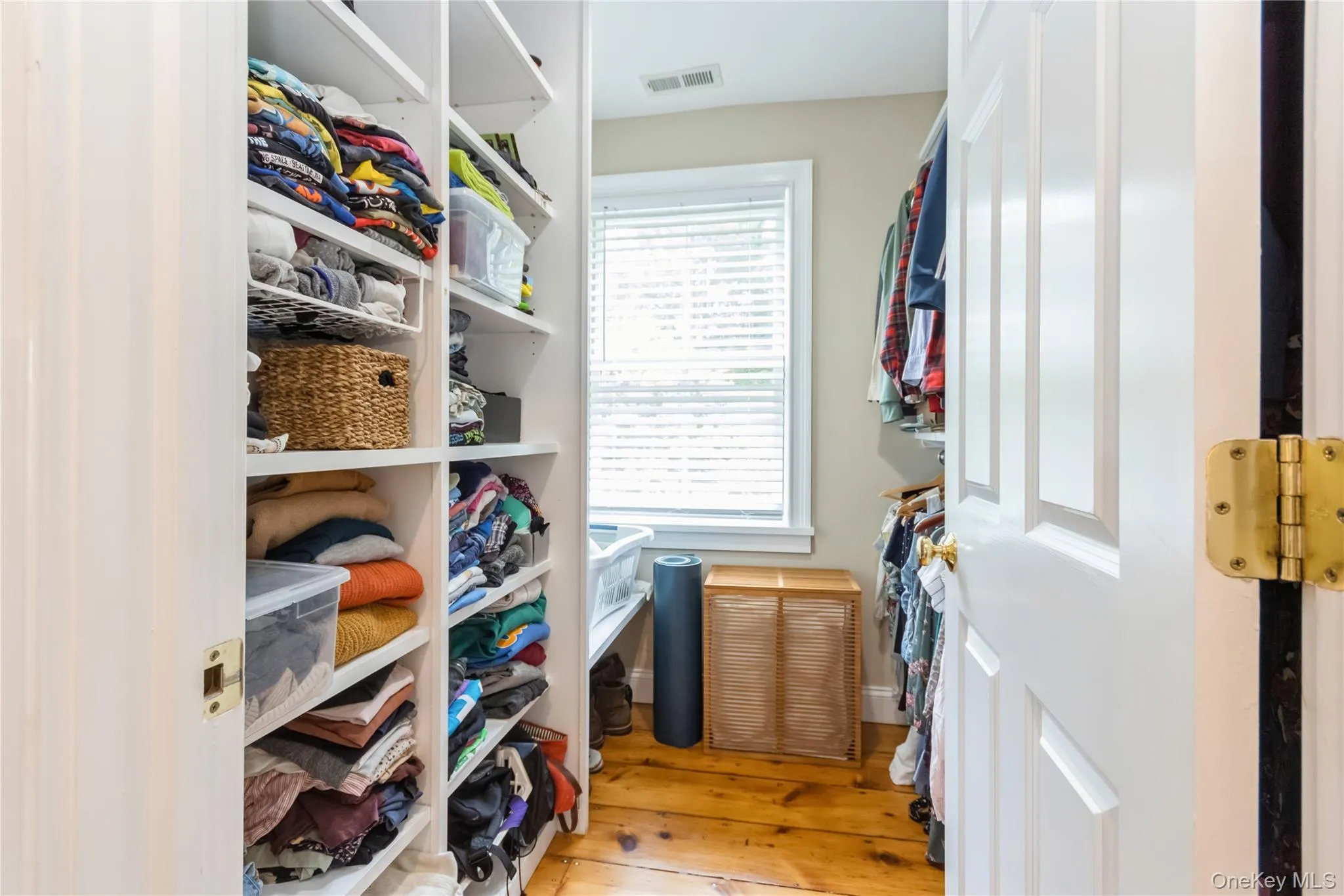 Walk in closet featuring hardwood / wood-style flooring Walk in closet featuring hardwood / wood-style flooring