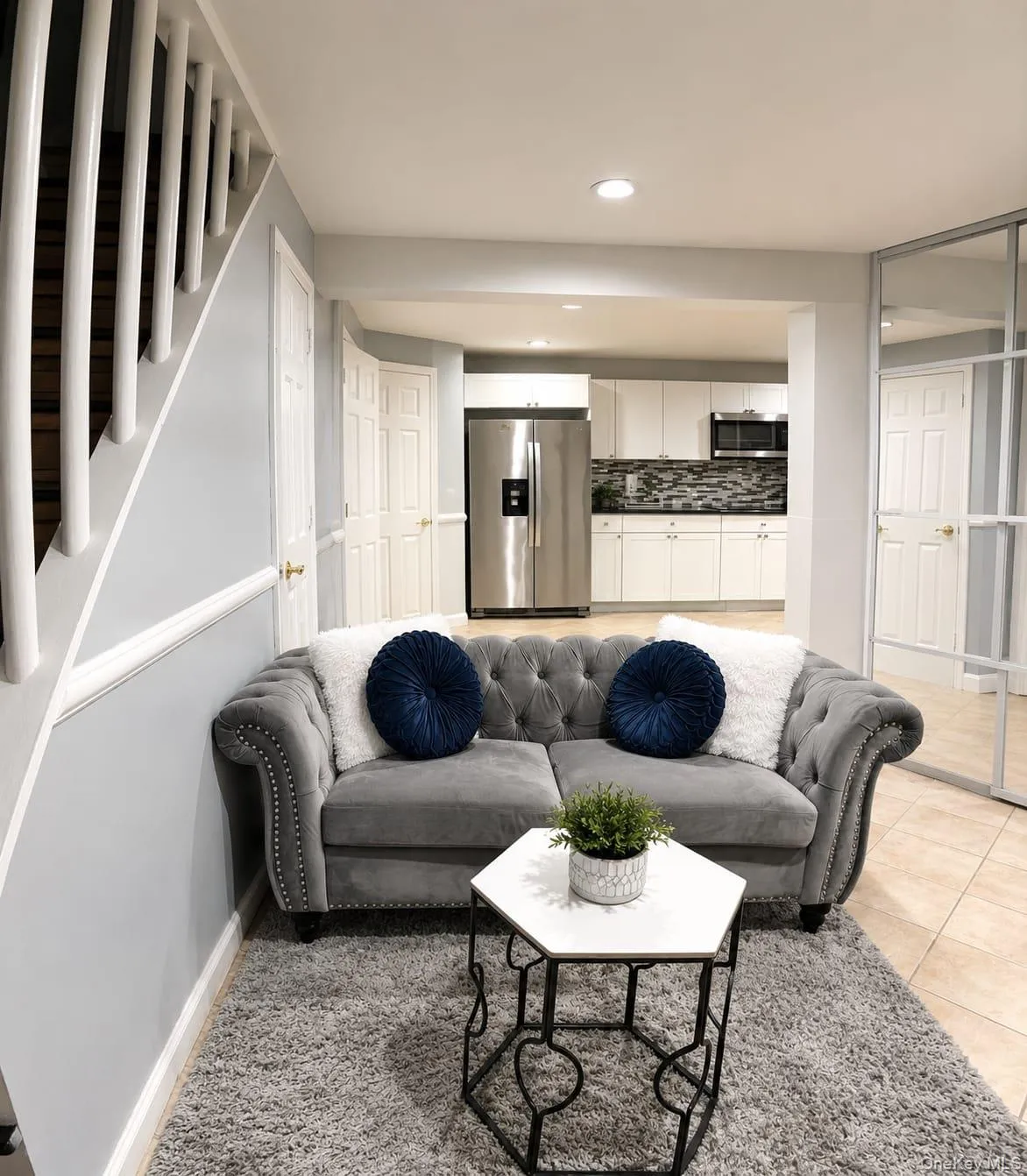 Open-concept living area with light-colored tile flooring and recessed lighting Open-concept living area with light-colored tile flooring and recessed lighting