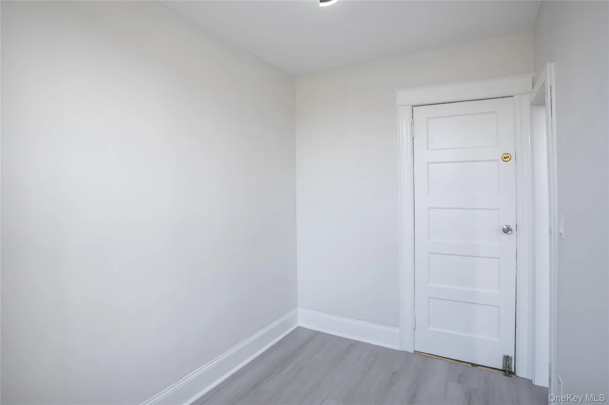 Spare room with light wood-style flooring and baseboards Spare room with light wood-style flooring and baseboards