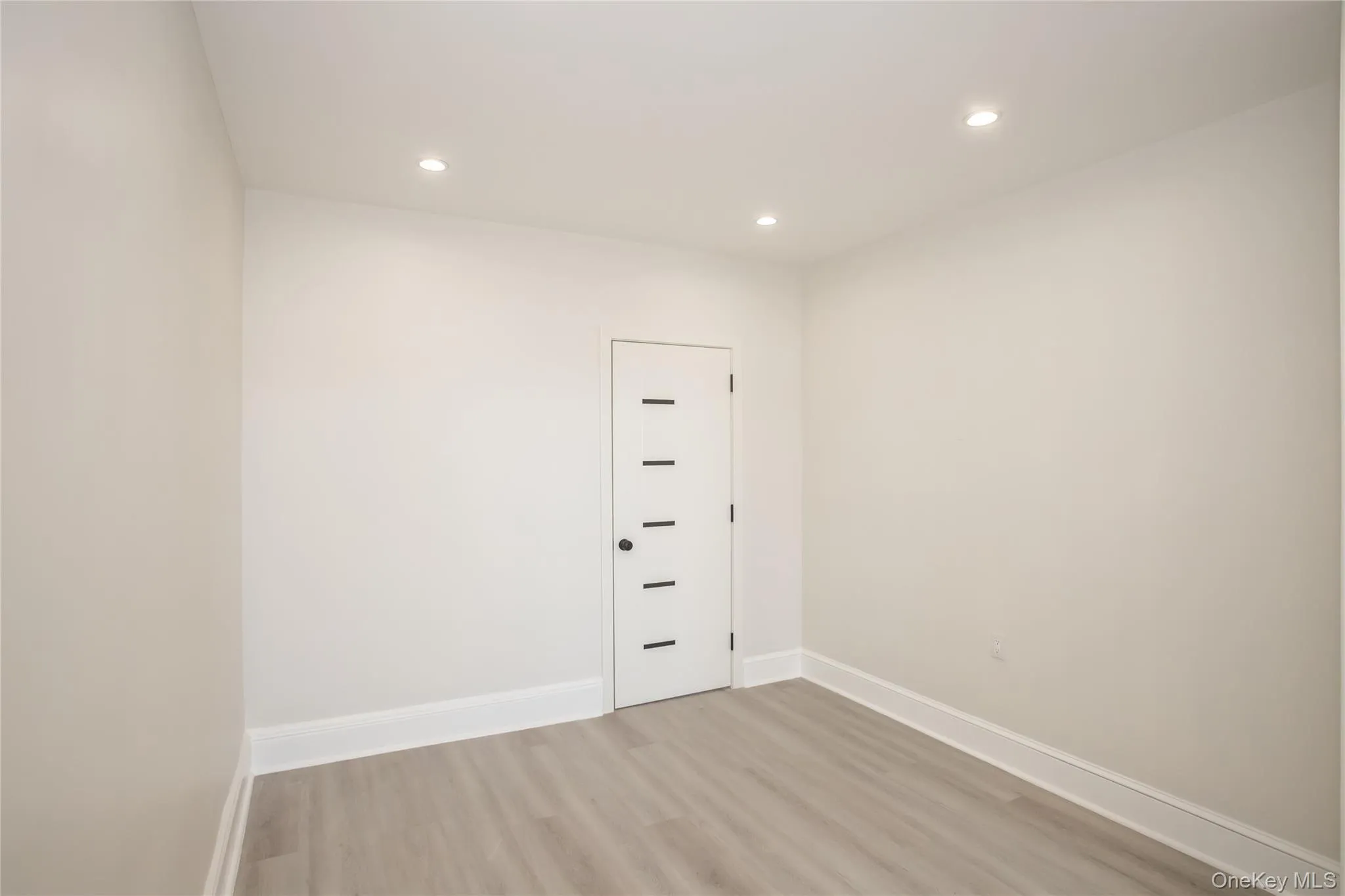 Empty room with light wood-type flooring, recessed lighting, and baseboards Empty room with light wood-type flooring, recessed lighting, and baseboards